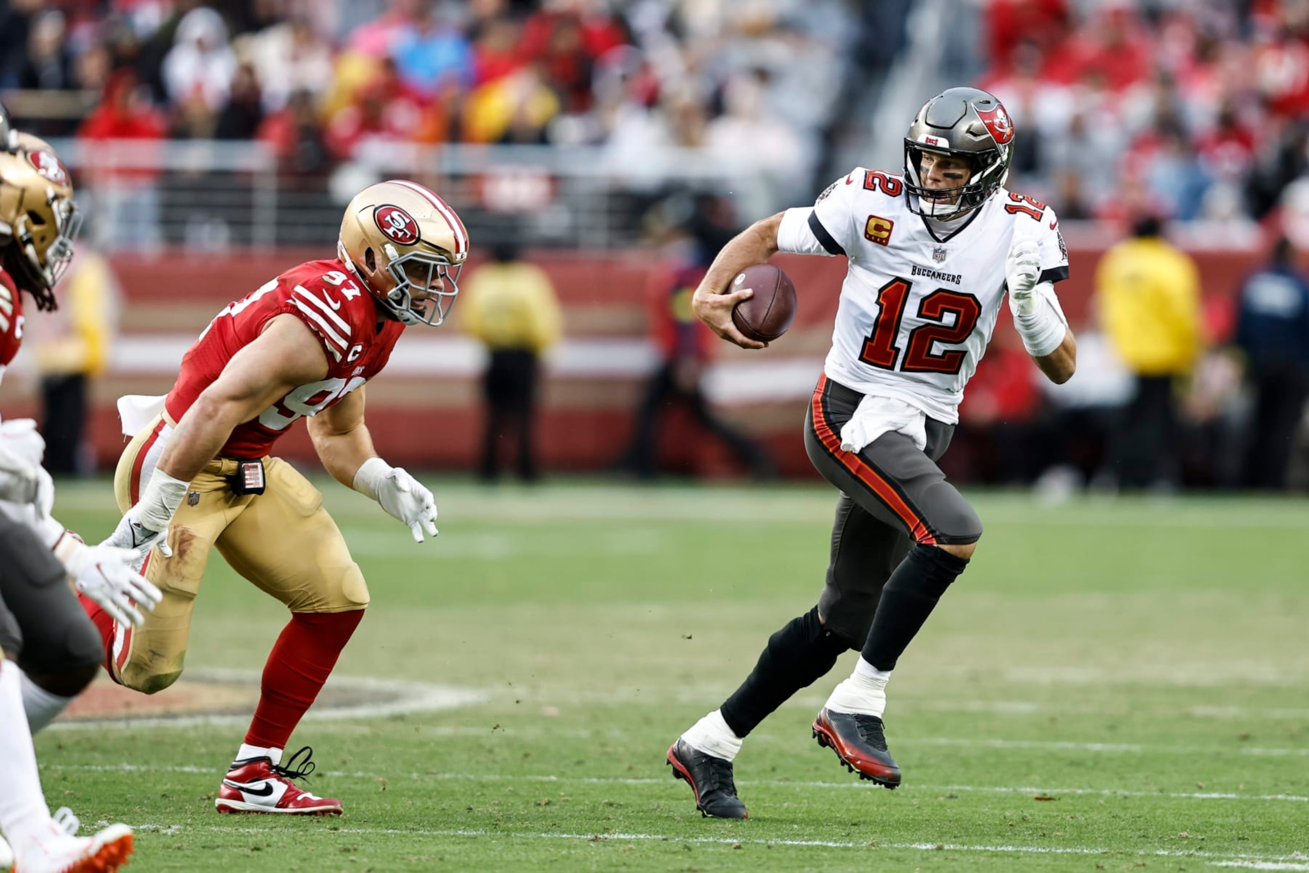 SANTA CLARA, CALIFORNIA - DECEMBER 11: Tom Brady #12 of the Tampa Bay Buccaneers scrambles and runs with the ball during an NFL football game between the San Francisco 49ers and the Tampa Bay Buccaneers at Levi's Stadium on December 11, 2022 in Santa Clara, California. (Photo by Michael Owens/Getty Images)