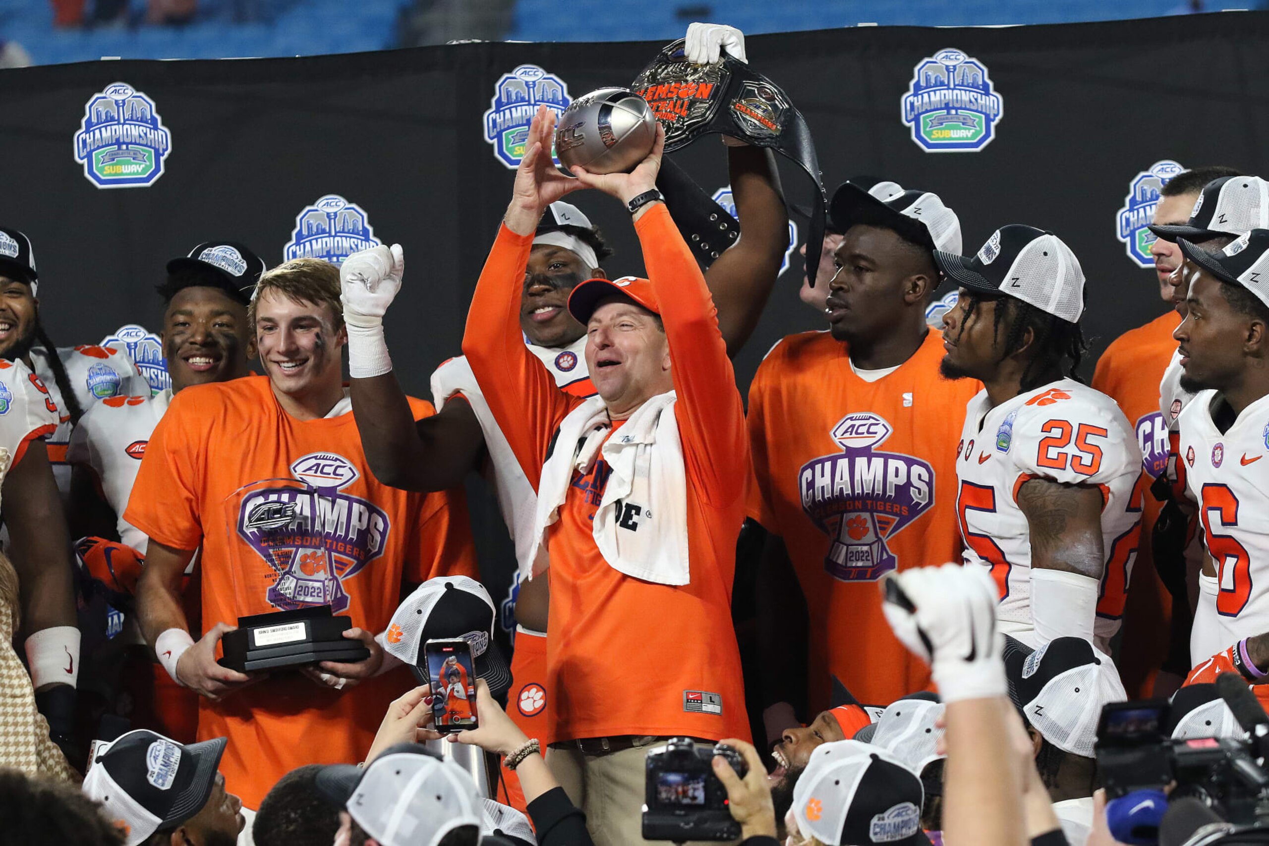 CHARLOTTE, NC - DECEMBER 03: Clemson Tigers quarterback Cade Klubnik (2) with his MVP award and Clemson Tigers head coach Dabo Swinney holds up the trophy after winning the ACC college football championship game between the North Carolina Tar Heels and the Clemson Tigers on December 3, 2022, at Bank of America Stadium in Charlotte, N.C. (Photo by John Byrum/Icon Sportswire via Getty Images)