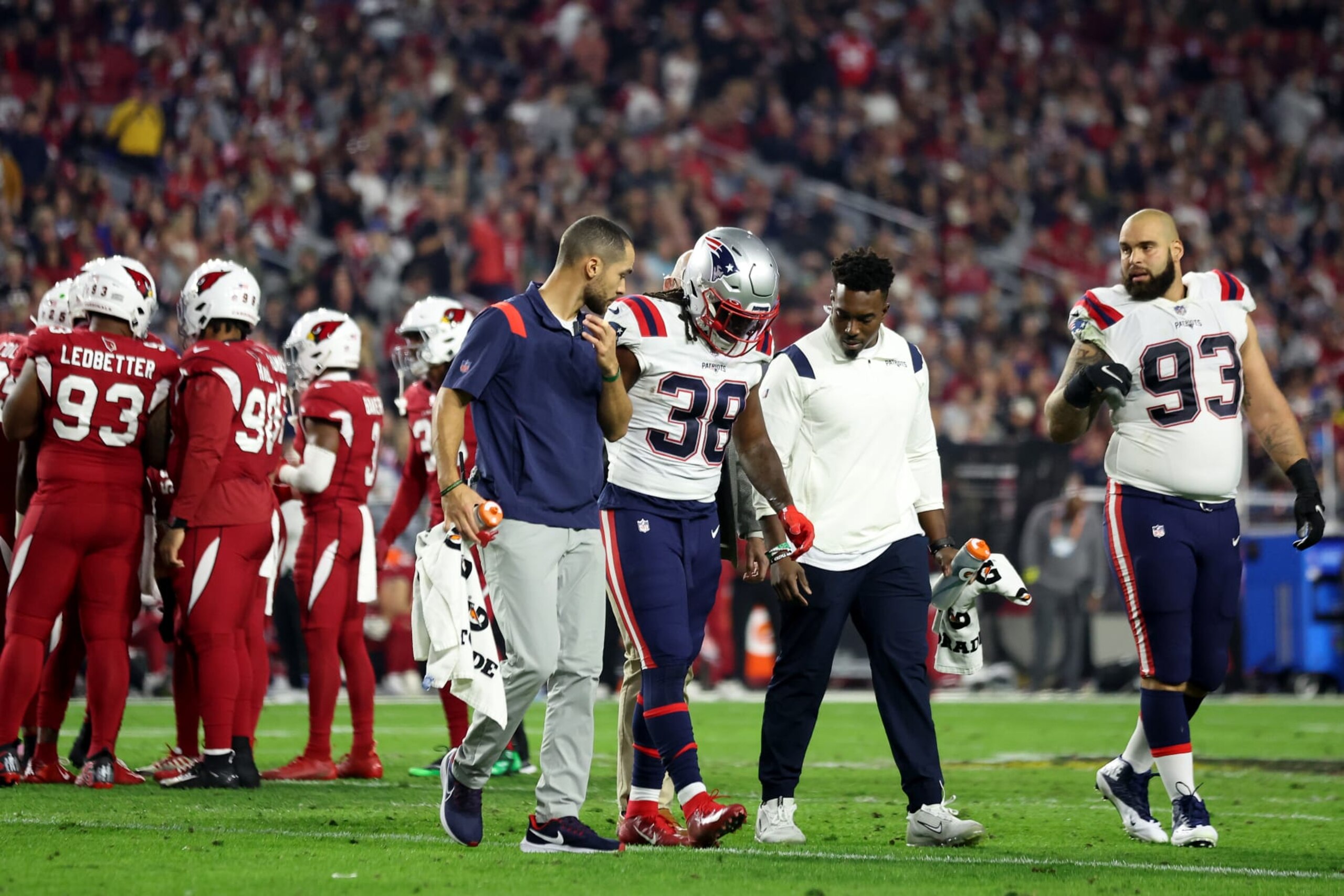 GLENDALE, ARIZONA - DECEMBER 12: Rhamondre Stevenson #38 of the New England Patriots is assisted off the field after a play against the Arizona Cardinals during the first quarter of the game at State Farm Stadium on December 12, 2022 in Glendale, Arizona. (Photo by Christian Petersen/Getty Images)