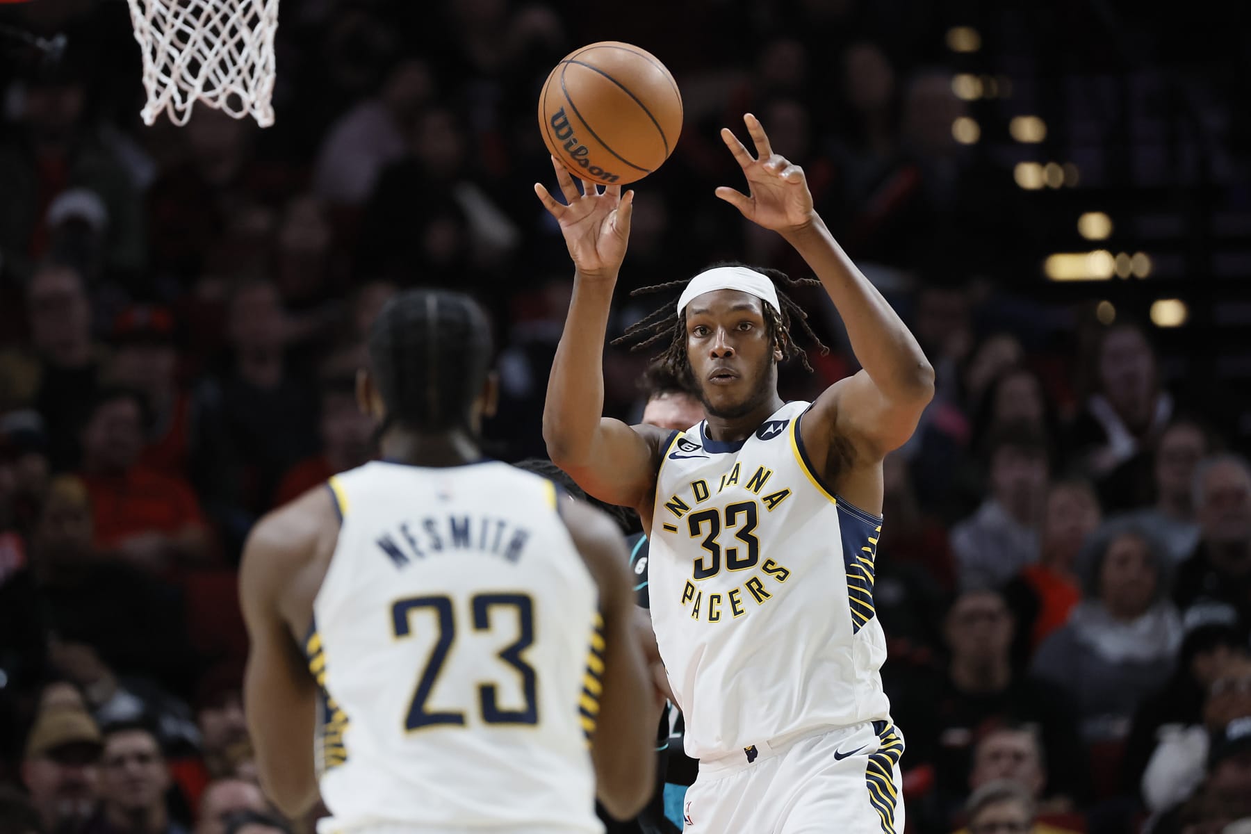 PORTLAND, OREGON - DECEMBER 04: Myles Turner #33 passes the ball to Aaron Nesmith #23 of the Indiana Pacers  during the first half against the Portland Trail Blazers at Moda Center on December 04, 2022 in Portland, Oregon. NOTE TO USER: User expressly acknowledges and agrees that, by downloading and or using this photograph, User is consenting to the terms and conditions of the Getty Images License Agreement. (Photo by Soobum Im/Getty Images)