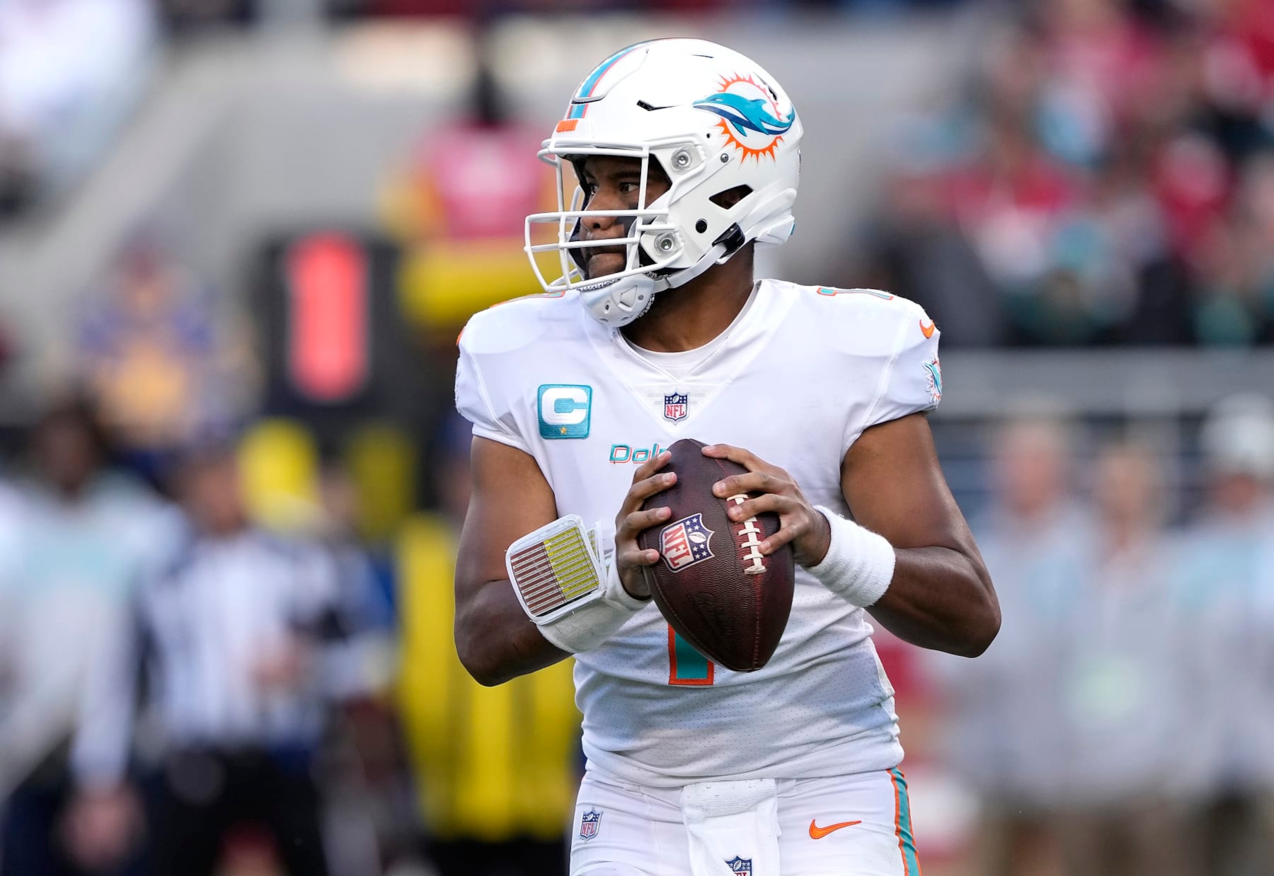SANTA CLARA, CALIFORNIA - DECEMBER 04: Tua Tagovailoa #1 of the Miami Dolphins rolls out to throw a pass against the San Francisco 49ers during the third quarter of an NFL football game at Levi's Stadium on December 04, 2022 in Santa Clara, California. (Photo by Thearon W. Henderson/Getty Images)