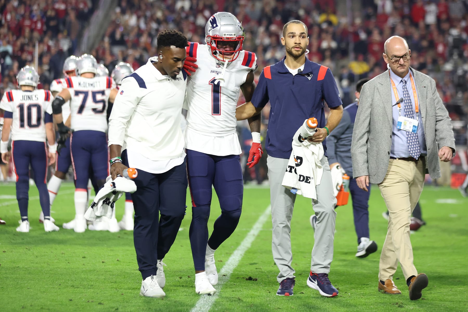 GLENDALE, ARIZONA - DECEMBER 12: DeVante Parker #1 of the New England Patriots is assisted off the field after a play against the Arizona Cardinals during the first quarter of the game at State Farm Stadium on December 12, 2022 in Glendale, Arizona. (Photo by Christian Petersen/Getty Images)