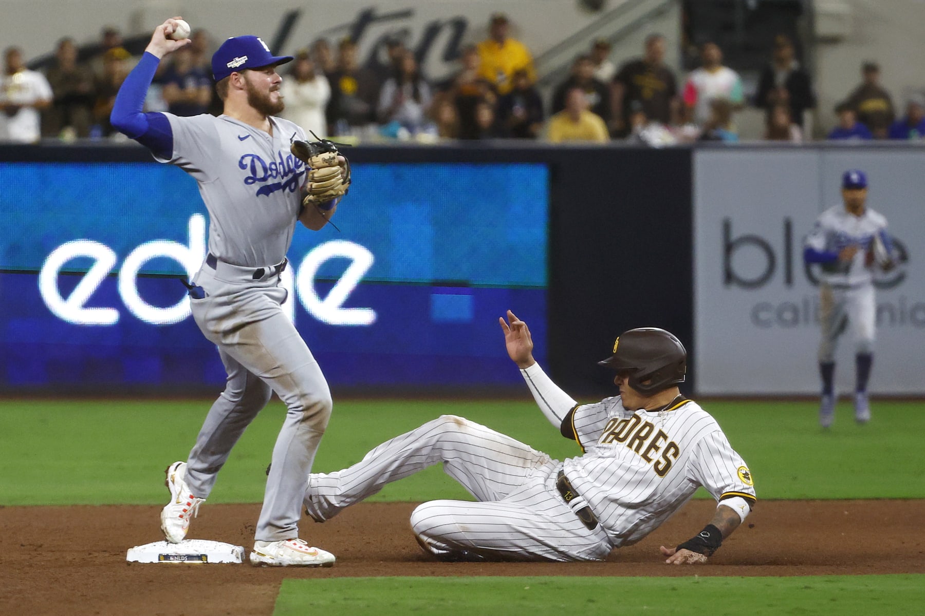 SAN DIEGO, CALIFORNIA - OCTOBER 15: Manny Machado #13 of the San Diego Padres is out at second base as Gavin Lux #9 of the Los Angeles Dodgers attempts to turn a double play during the sixth inning in game four of the National League Division Series at PETCO Park on October 15, 2022 in San Diego, California. (Photo by Ronald Martinez/Getty Images)