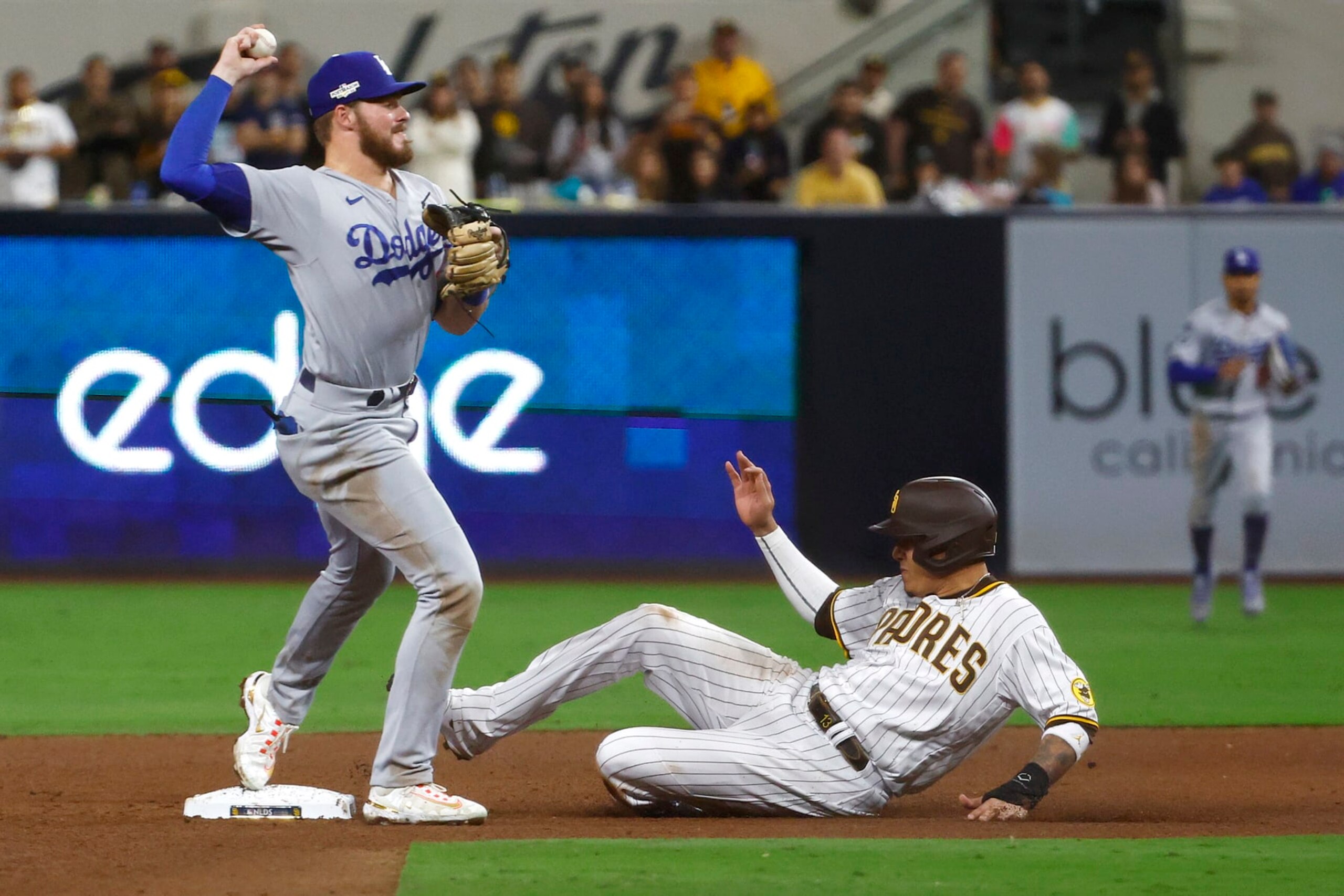 SAN DIEGO, CALIFORNIA - OCTOBER 15: Manny Machado #13 of the San Diego Padres is out at second base as Gavin Lux #9 of the Los Angeles Dodgers attempts to turn a double play during the sixth inning in game four of the National League Division Series at PETCO Park on October 15, 2022 in San Diego, California. (Photo by Ronald Martinez/Getty Images)