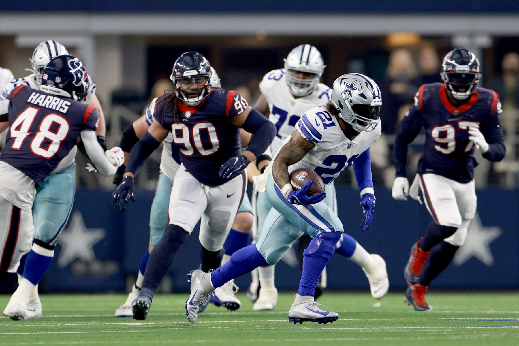 ARLINGTON, TEXAS - DECEMBER 11: Running back Ezekiel Elliott #21 of the Dallas Cowboys carries the ball against linebacker Christian Kirksey #58 of the Houston Texans in the fourth quarter at AT&T Stadium on December 11, 2022 in Arlington, Texas. (Photo by Tom Pennington/Getty Images)