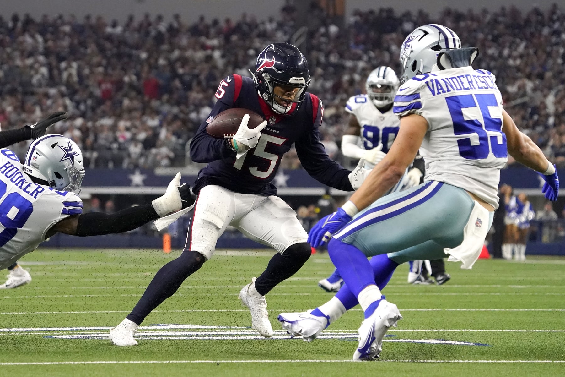 ARLINGTON, TEXAS - DECEMBER 11: Chris Moore #15 of the Houston Texans runs with the ball as Leighton Vander Esch #55 of the Dallas Cowboys looks to make a tackle in the fourth quarter at AT&T Stadium on December 11, 2022 in Arlington, Texas. (Photo by Sam Hodde/Getty Images)