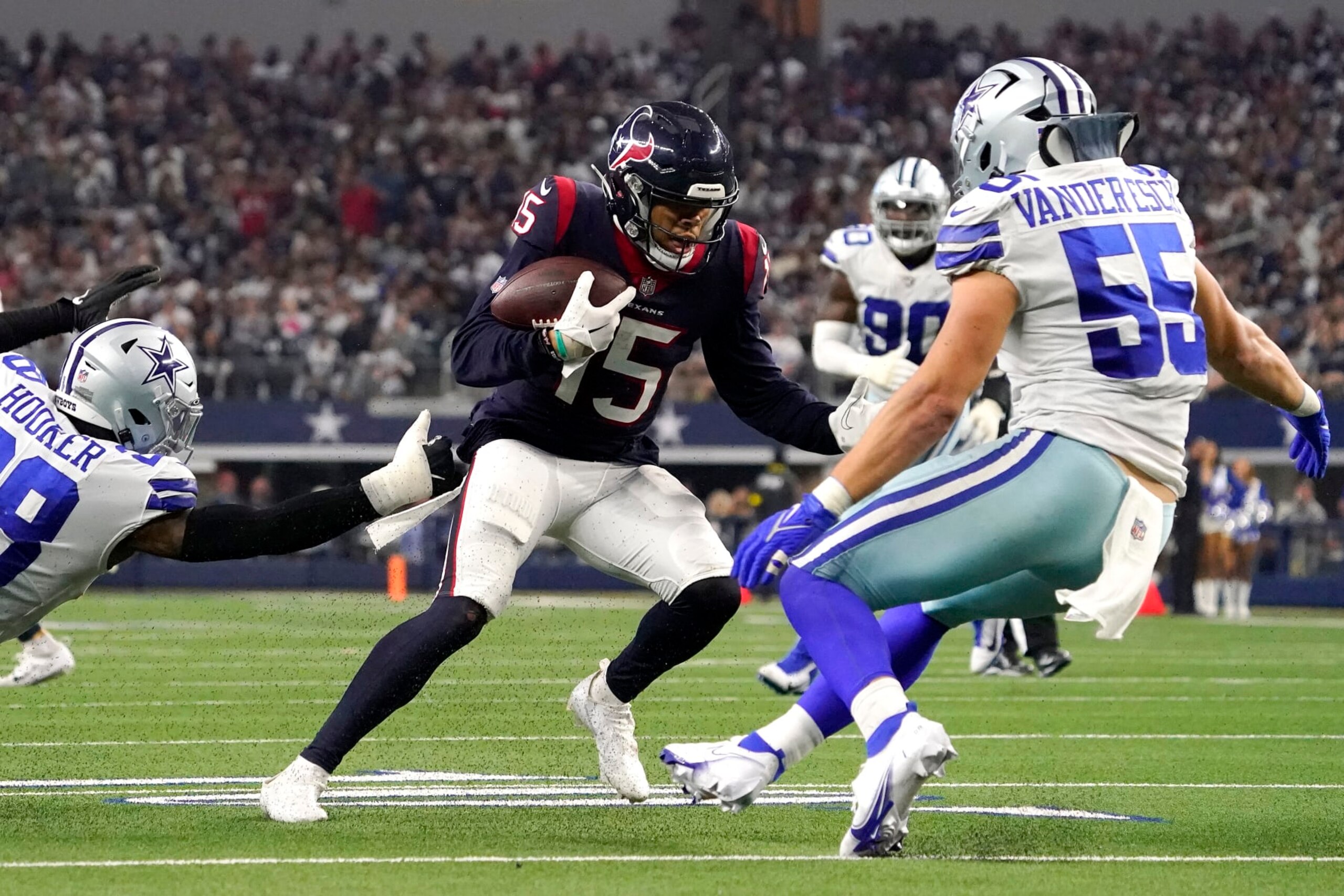 ARLINGTON, TEXAS - DECEMBER 11: Chris Moore #15 of the Houston Texans runs with the ball as Leighton Vander Esch #55 of the Dallas Cowboys looks to make a tackle in the fourth quarter at AT&T Stadium on December 11, 2022 in Arlington, Texas. (Photo by Sam Hodde/Getty Images)