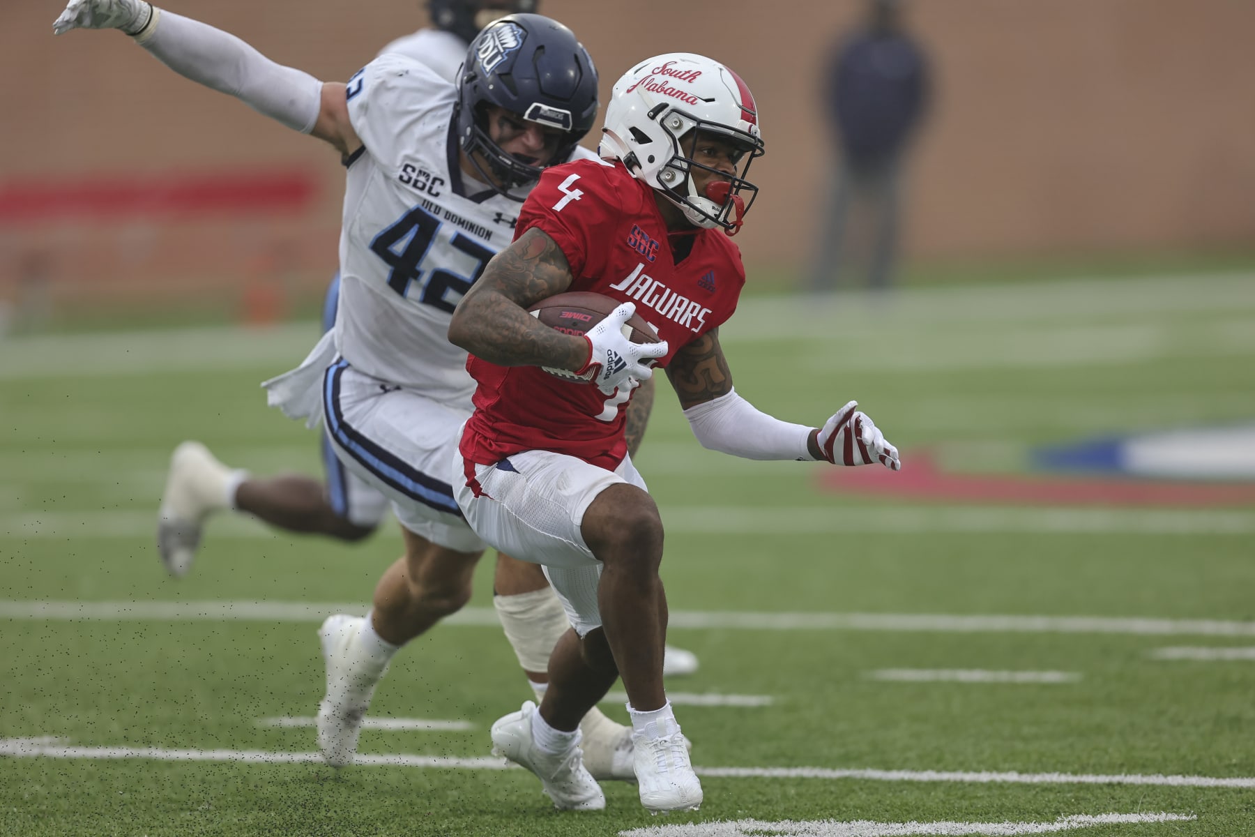 MOBILE, AL - NOVEMBER 26: South Alabama Jaguars wide receiver Caullin Lacy (4) tries to escape Old Dominion Monarchs linebacker Jason Henderson (42) during a college football game between the Old Dominion Monarchs and the South Alabama Jaguars on November 26, 2022, at Hancock-Whitney Stadium, Mobile, Alabama.  (Photo by Bobby McDuffie/Icon Sportswire via Getty Images)