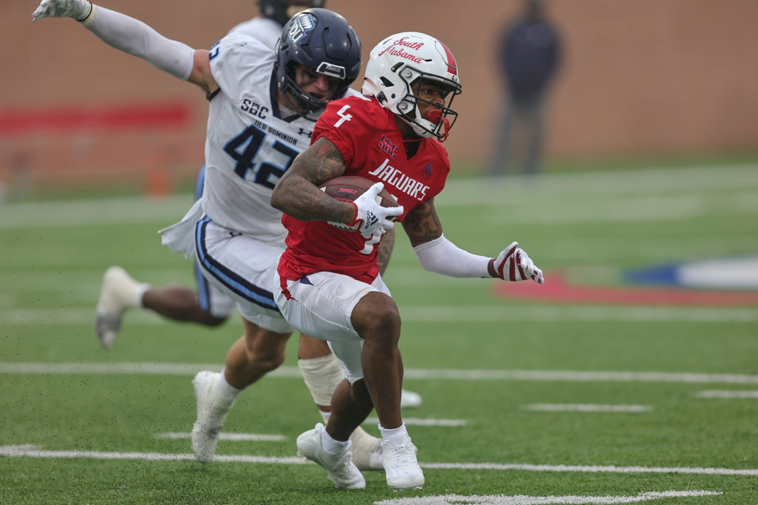 MOBILE, AL - NOVEMBER 26: South Alabama Jaguars wide receiver Caullin Lacy (4) tries to escape Old Dominion Monarchs linebacker Jason Henderson (42) during a college football game between the Old Dominion Monarchs and the South Alabama Jaguars on November 26, 2022, at Hancock-Whitney Stadium, Mobile, Alabama.  (Photo by Bobby McDuffie/Icon Sportswire via Getty Images)
