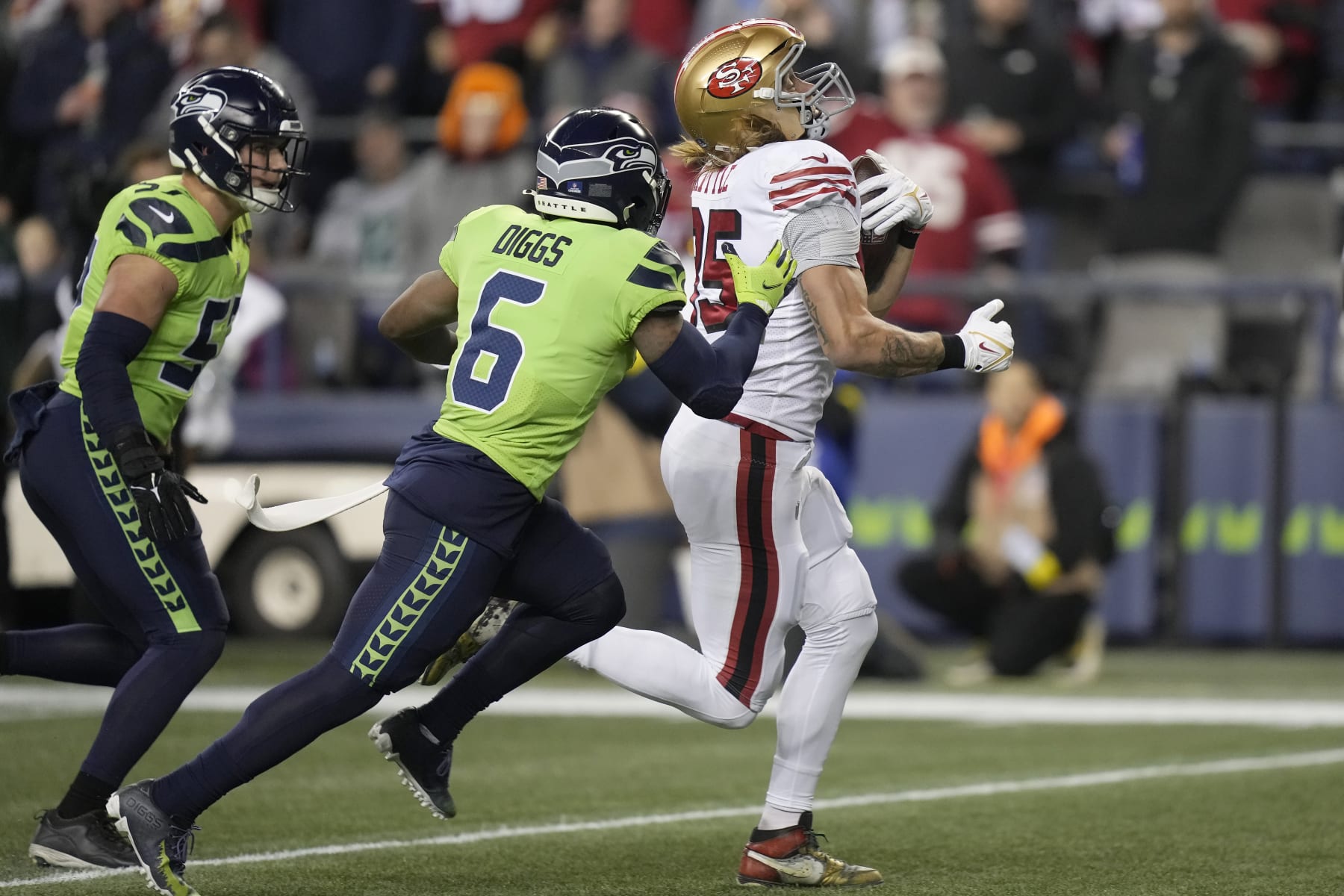 San Francisco 49ers tight end George Kittle, right, runs toward the end zone to score past Seattle Seahawks safety Quandre Diggs (6) and linebacker Cody Barton during the first half of an NFL football game in Seattle, Thursday, Dec. 15, 2022. (AP Photo/Stephen Brashear)