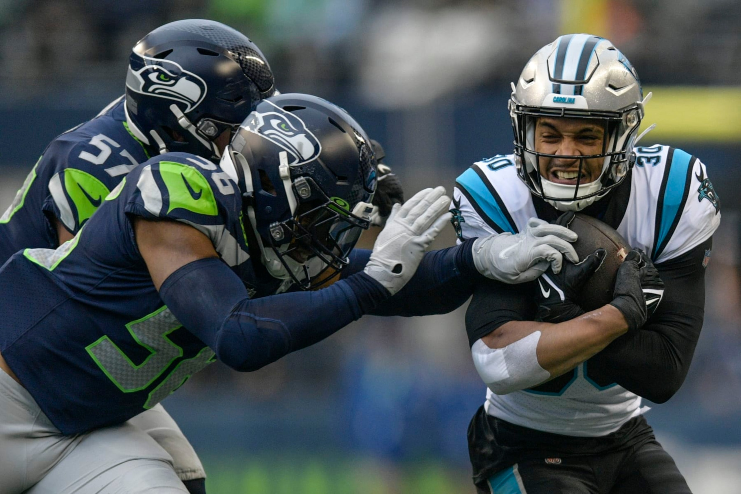 Carolina Panthers running back Chuba Hubbard (30) runs against Seattle Seahawks linebacker Cody Barton (57) during the first half of an NFL football game, Sunday, Dec. 11, 2022, in Seattle. (AP Photo/Caean Couto)