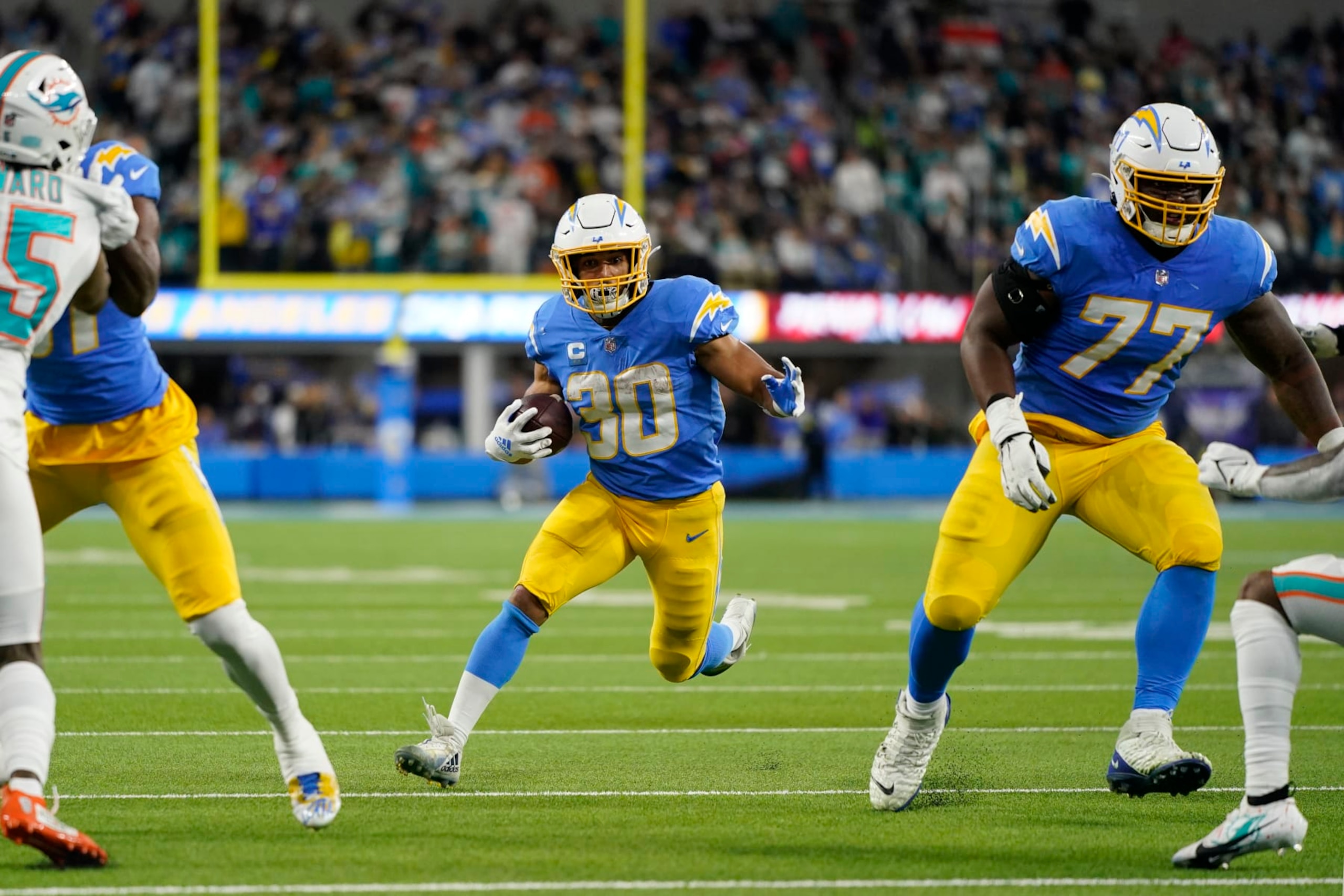 Los Angeles Chargers running back Austin Ekeler (30) runs behind guard Zion Johnson (77) during the first half of an NFL football game against the Miami Dolphins Sunday, Dec. 11, 2022, in Inglewood, Calif. (AP Photo/Jae C. Hong) Los Angeles Chargers running back Austin Ekeler (30) runs behind guard Zion Johnson (77) during the first half of an NFL football game against the Miami Dolphins Sunday, Dec. 11, 2022, in Inglewood, Calif. (AP Photo/Jae C. Hong)