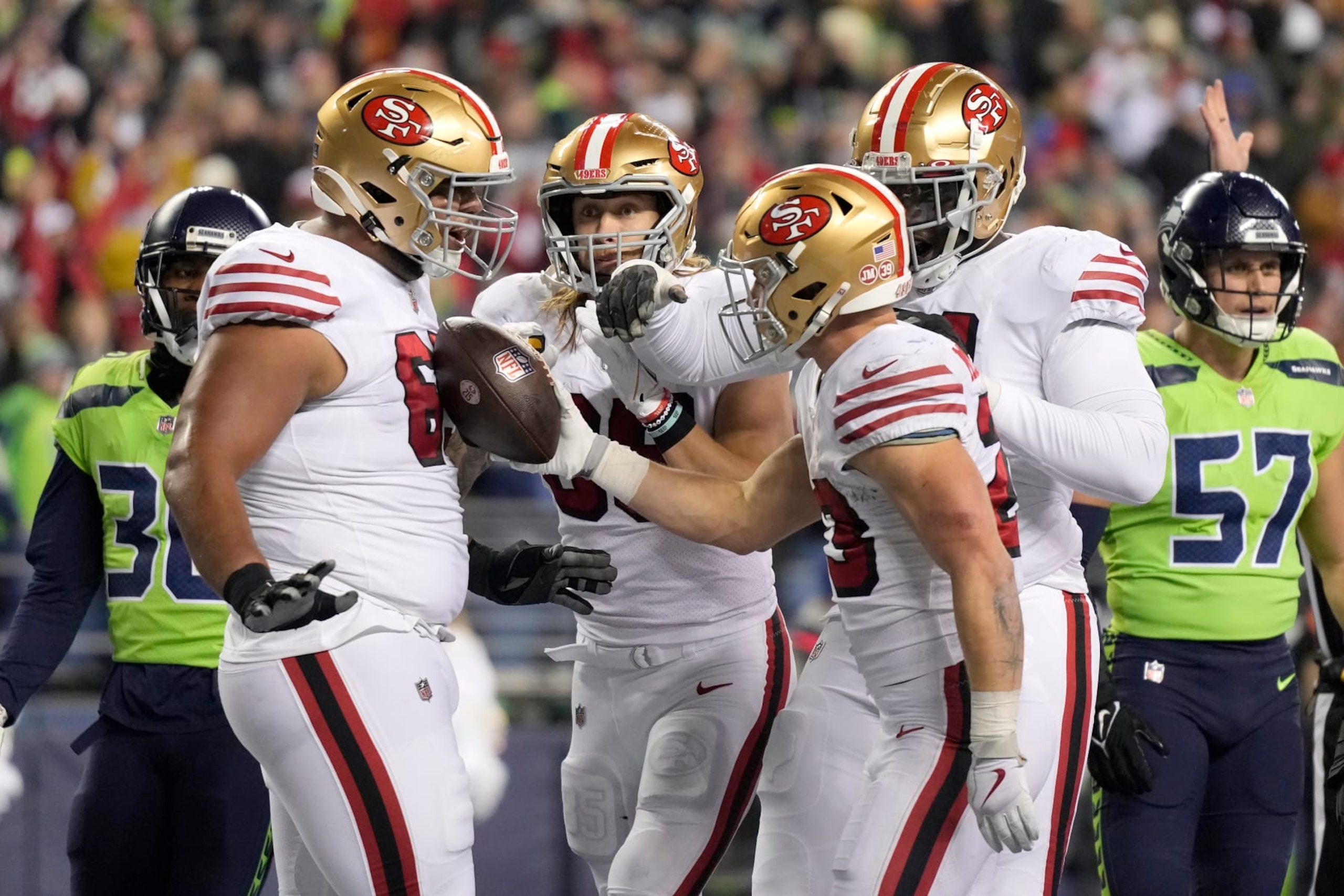 San Francisco 49ers running back Christian McCaffrey, middle right, is congratulated by teammates after scoring against the Seattle Seahawks during the first half of an NFL football game in Seattle, Thursday, Dec. 15, 2022. (AP Photo/Stephen Brashear) San Francisco 49ers running back Christian McCaffrey, middle right, is congratulated by teammates after scoring against the Seattle Seahawks during the first half of an NFL football game in Seattle, Thursday, Dec. 15, 2022. (AP Photo/Stephen Brashear)