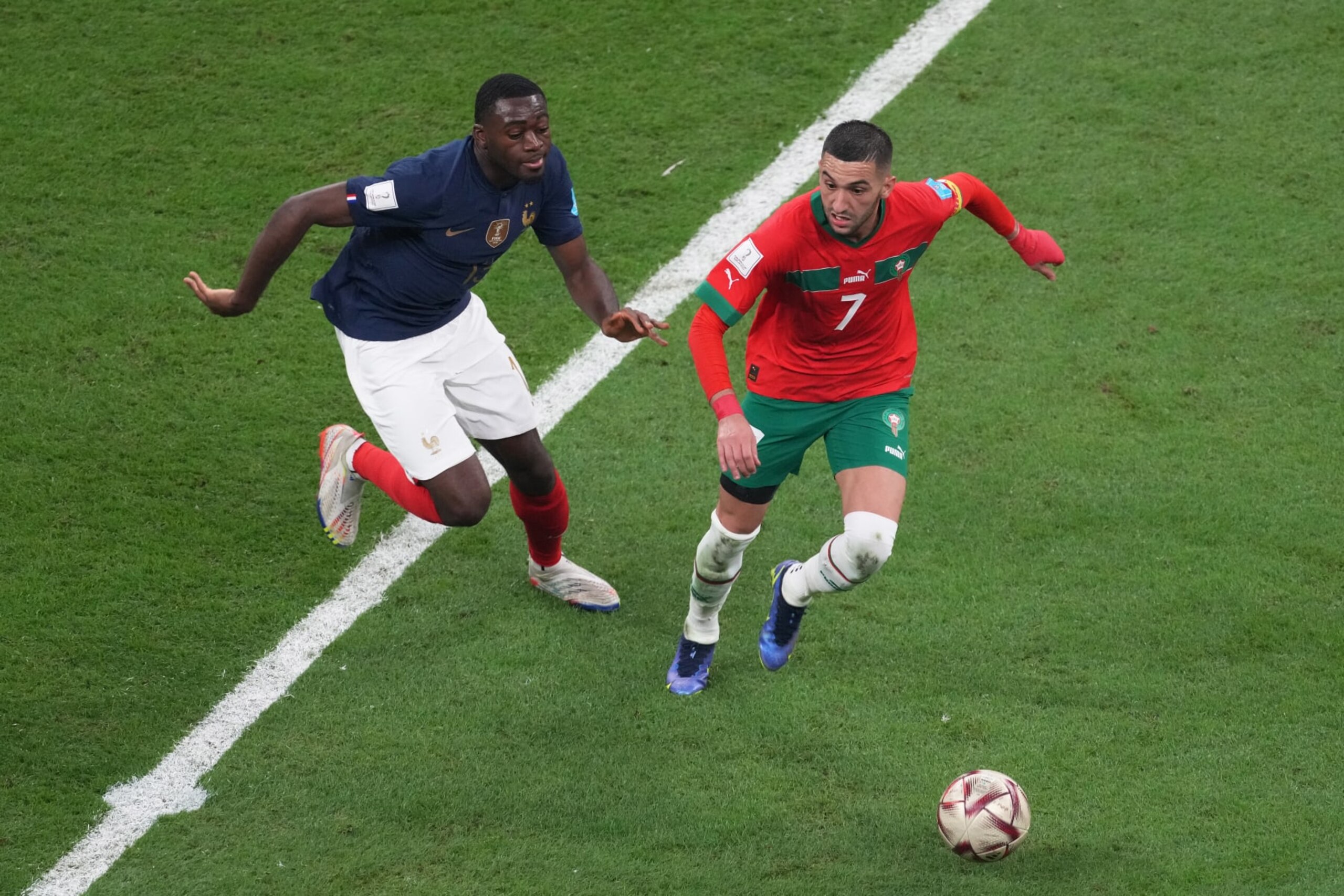 AL KHOR, QATAR - DECEMBER 14: Hakim Ziyech of Morocco in action under pressure from Youssouf Fofana of France during the FIFA World Cup Qatar 2022 semi final match between France and Morocco at Al Bayt Stadium on December 14, 2022 in Al Khor, Qatar. (Photo by Etsuo Hara/Getty Images)
