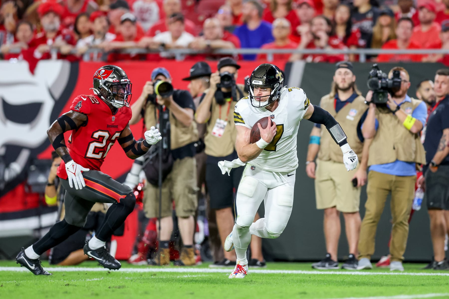 TAMPA, FLORIDA - DECEMBER 5: Taysom Hill #7 of the New Orleans Saints runs past Keanu Neal #22 of the Tampa Bay Buccaneers to score at Raymond James Stadium on December 5, 2022 in Tampa, Florida. (Photo by Mike Carlson/Getty Images)