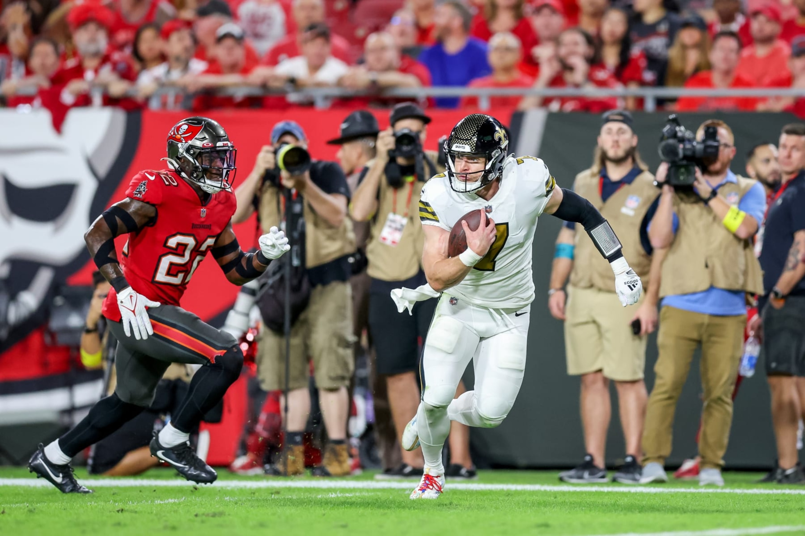 TAMPA, FLORIDA - DECEMBER 5: Taysom Hill #7 of the New Orleans Saints runs past Keanu Neal #22 of the Tampa Bay Buccaneers to score at Raymond James Stadium on December 5, 2022 in Tampa, Florida. (Photo by Mike Carlson/Getty Images)