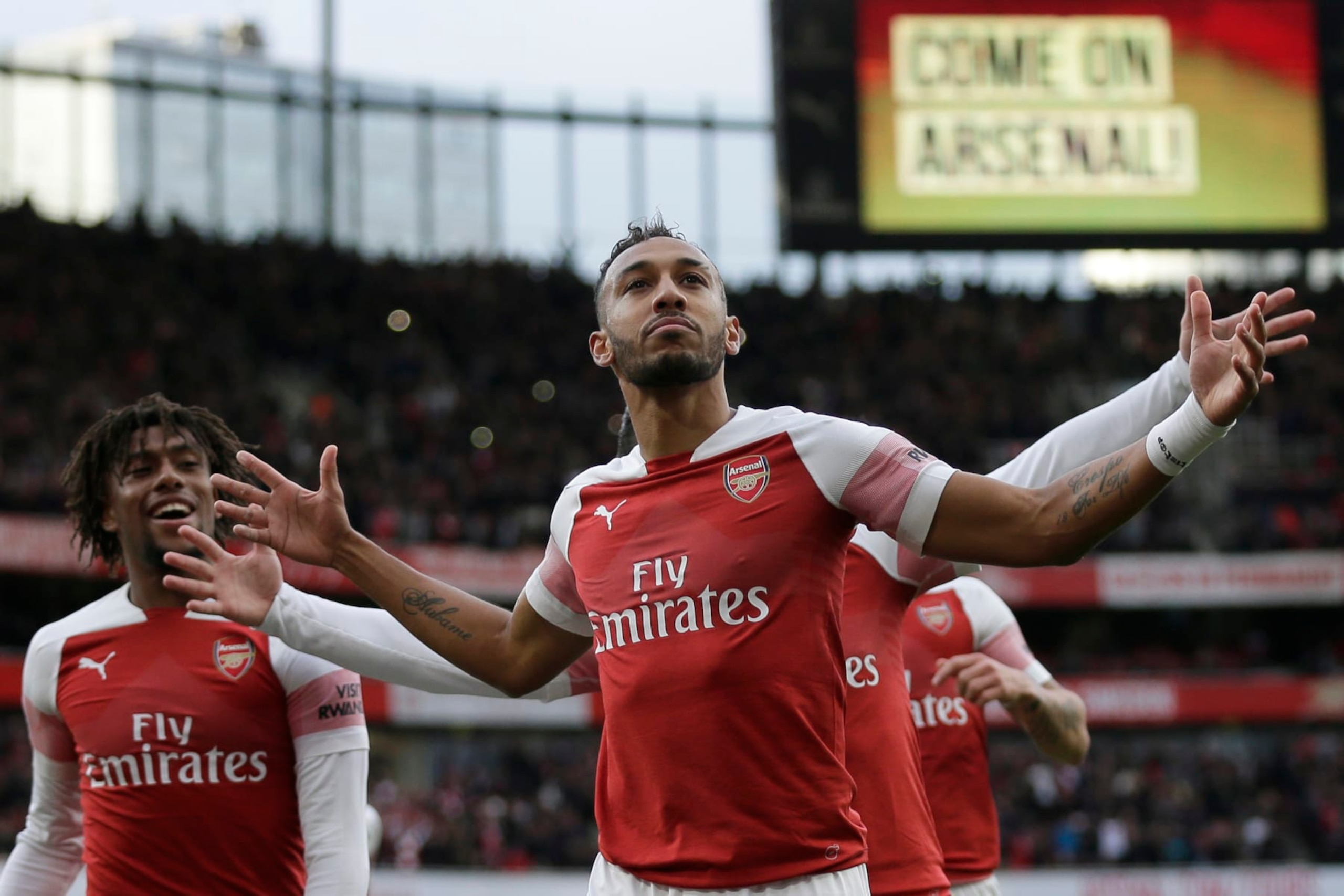 Arsenal's Pierre-Emerick Aubameyang celebrates with his teammates after scoring his side's opening goal from a penalty spot during the English Premier League soccer match between Arsenal and Tottenham Hotspur at the Emirates Stadium in London, Sunday Dec. 2, 2018. (AP Photo/Tim Ireland)