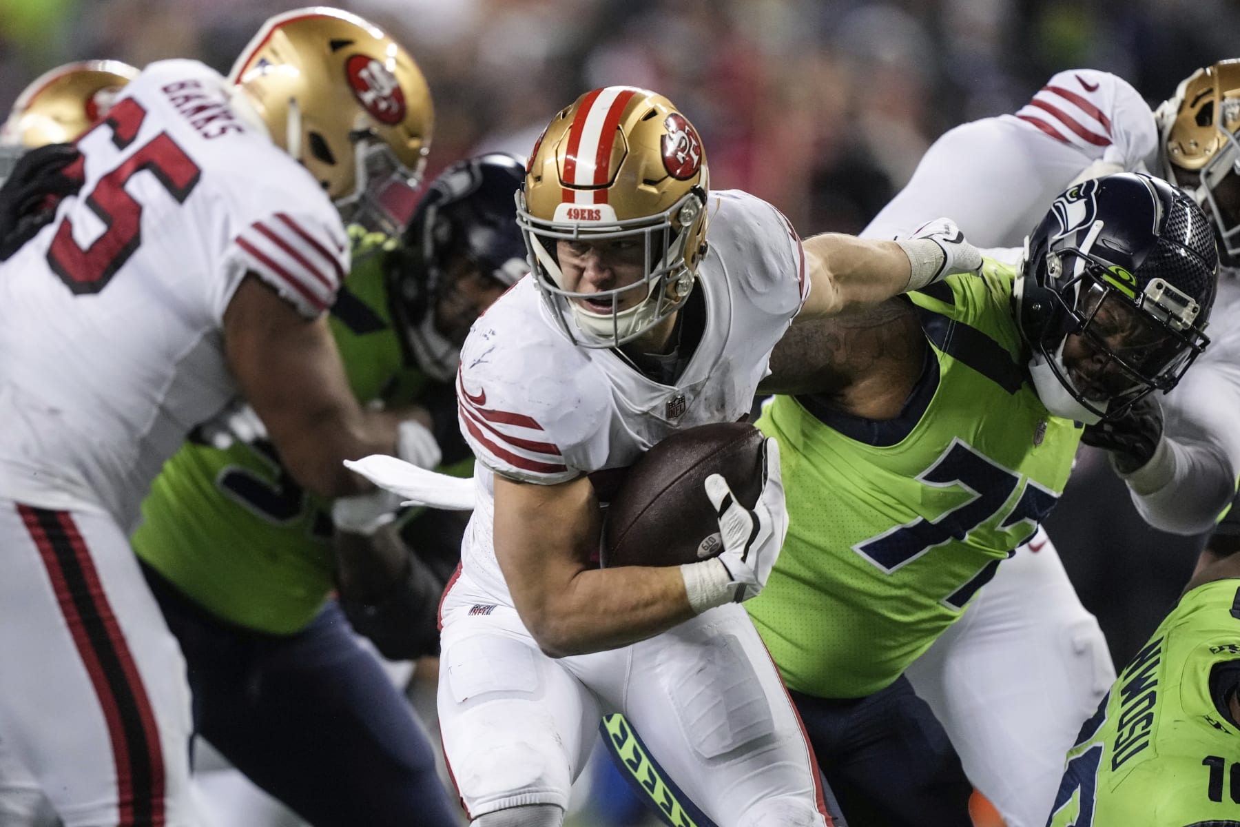 San Francisco 49ers running back Christian McCaffrey breaks the tackle of Seattle Seahawks defensive end Quinton Jefferson during an NFL football game , Thursday, Dec. 15, 2022, in Seattle. The 49ers won 21-13. (AP Photo/Stephen Brashear)