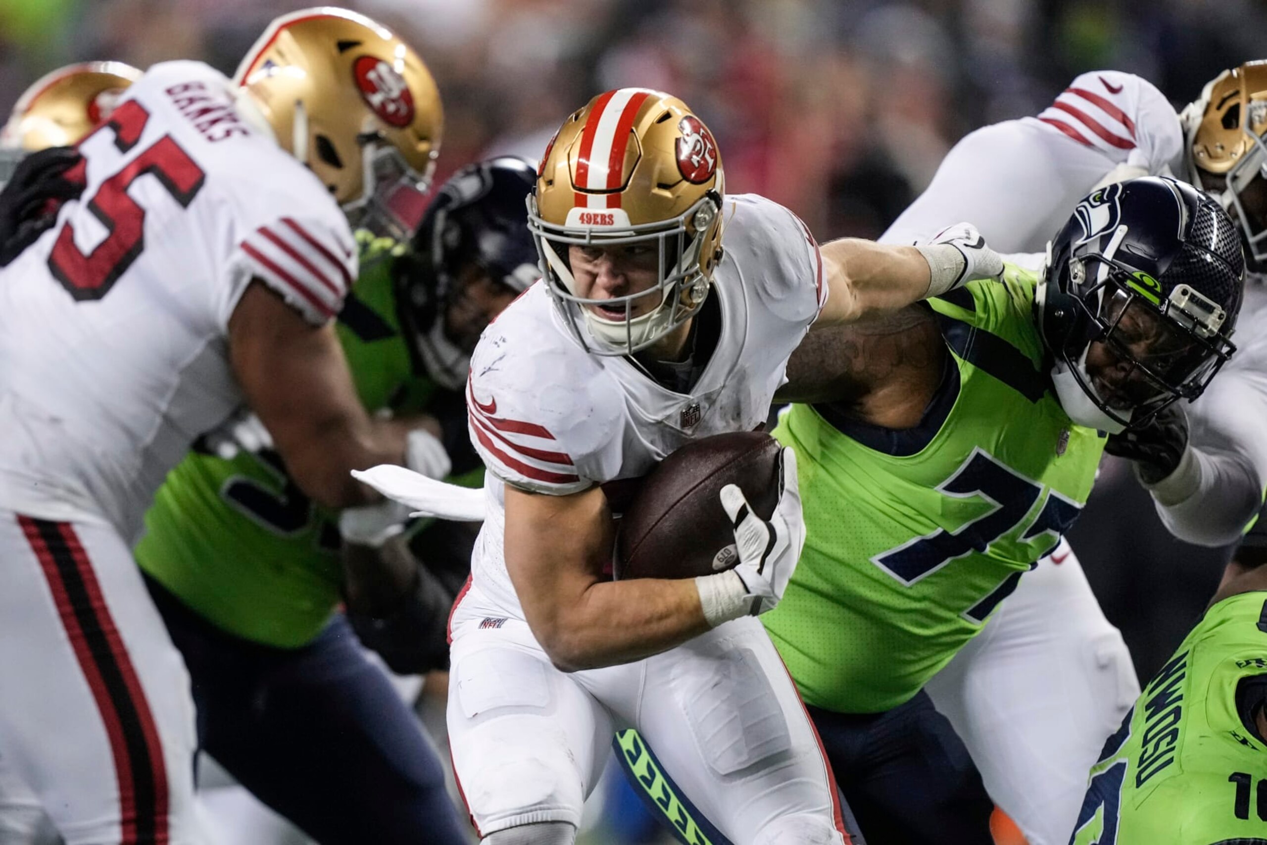 San Francisco 49ers running back Christian McCaffrey breaks the tackle of Seattle Seahawks defensive end Quinton Jefferson during an NFL football game , Thursday, Dec. 15, 2022, in Seattle. The 49ers won 21-13. (AP Photo/Stephen Brashear)