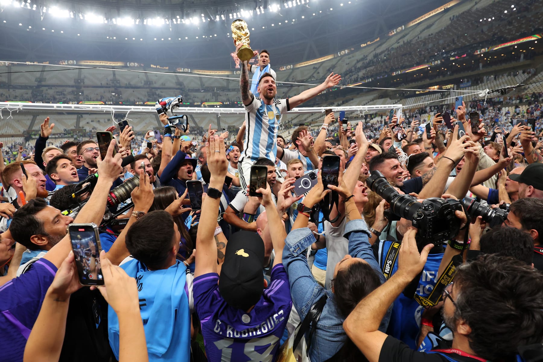 LUSAIL CITY, QATAR - DECEMBER 18: Lionel Messi of Argentina celebrates on Sergio Aguero of Argentina's shoulders with the FIFA World Cup Trophy following his team's victory in during the FIFA World Cup Qatar 2022 Final match between Argentina and France at Lusail Stadium on December 18, 2022 in Lusail City, Qatar. (Photo by Marc Atkins/Getty Images)