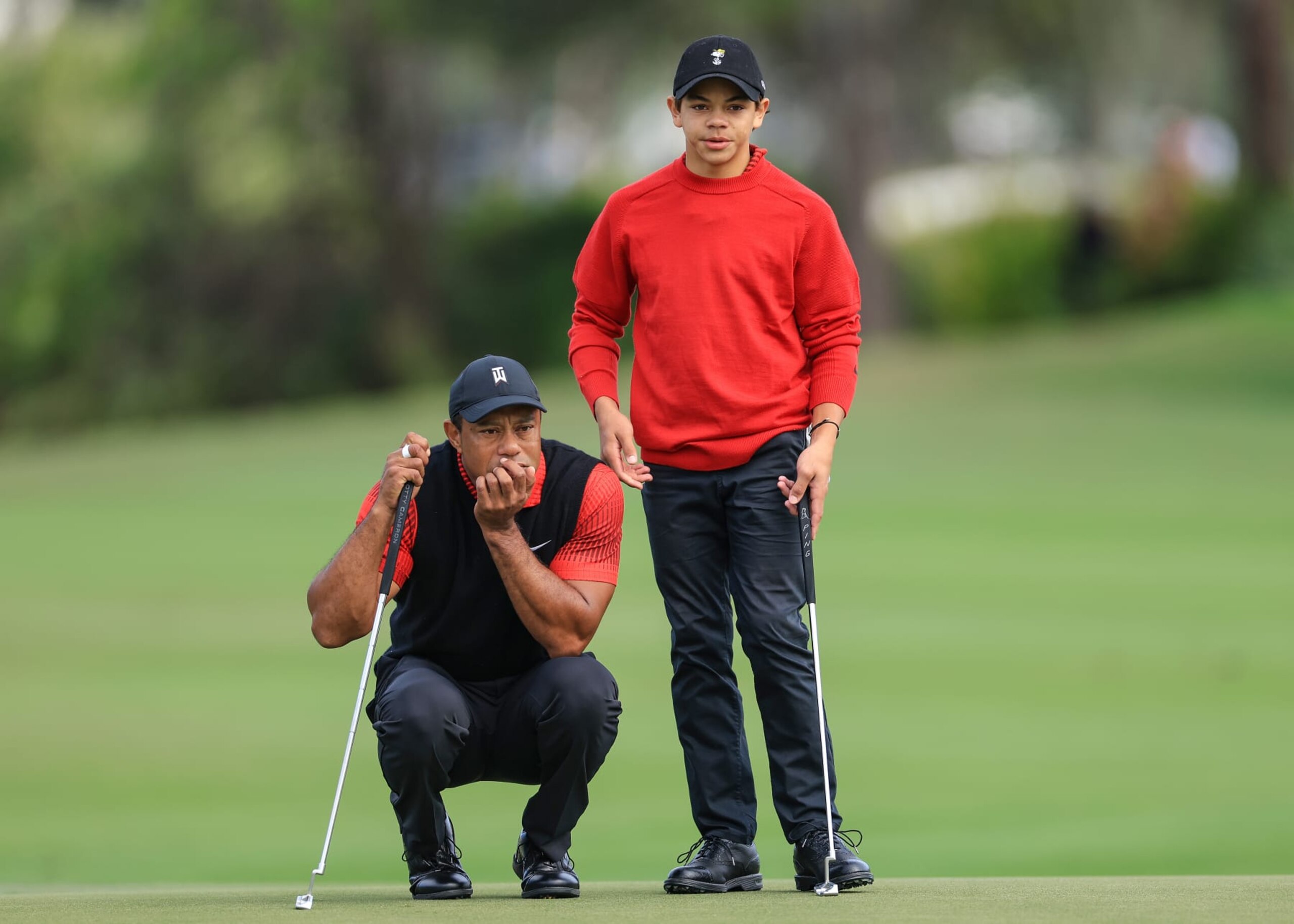 ORLANDO, FLORIDA - DECEMBER 18: Tiger Woods of The United States lines up a putt with his son Charlie Woods on the second hole during the final round of the 2022 PNC Championship at The Ritz-Carlton Golf Club on December 18, 2022 in Orlando, Florida. (Photo by David Cannon/Getty Images)
