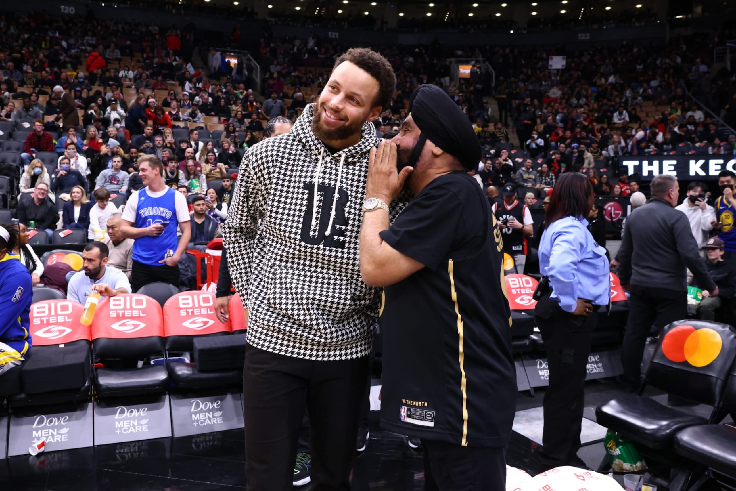 TORONTO, CANADA - DECEMBER 18: Stephen Curry #30 of the Golden State Warriors talks with Toronto Raptors Super Fan, Nav Bhatia on December 18, 2022 at the Scotiabank Arena in Toronto, Ontario, Canada.  NOTE TO USER: User expressly acknowledges and agrees that, by downloading and or using this Photograph, user is consenting to the terms and conditions of the Getty Images License Agreement.  Mandatory Copyright Notice: Copyright 2022 NBAE (Photo by Vaughn Ridley/NBAE via Getty Images)