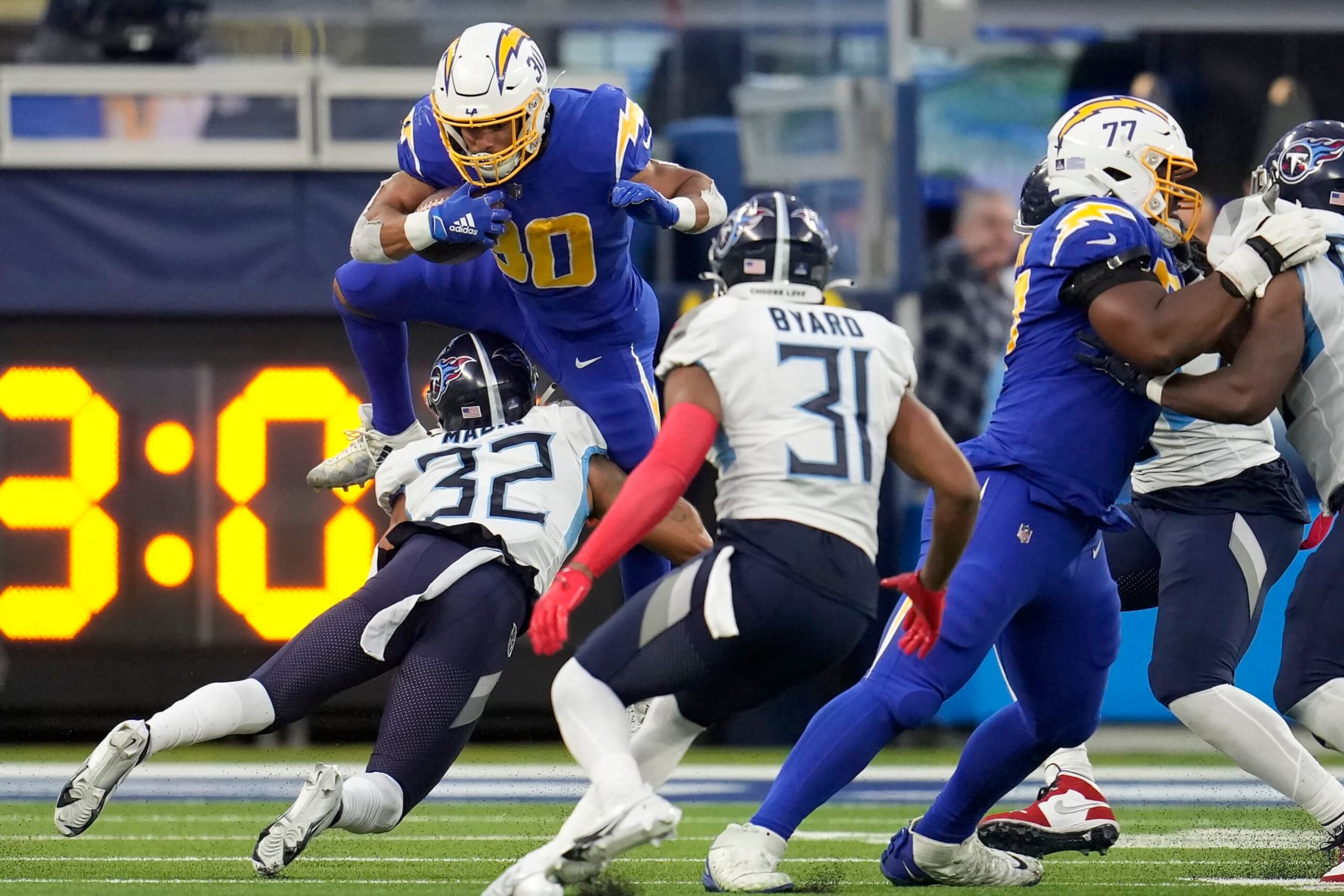 Los Angeles Chargers running back Austin Ekeler, top, runs against Tennessee Titans cornerback Greg Mabin (32) and safety Kevin Byard (31) during the second half of an NFL football game in Inglewood, Calif., Sunday, Dec. 18, 2022. (AP Photo/Marcio Jose Sanchez) Los Angeles Chargers running back Austin Ekeler, top, runs against Tennessee Titans cornerback Greg Mabin (32) and safety Kevin Byard (31) during the second half of an NFL football game in Inglewood, Calif., Sunday, Dec. 18, 2022. (AP Photo/Marcio Jose Sanchez)