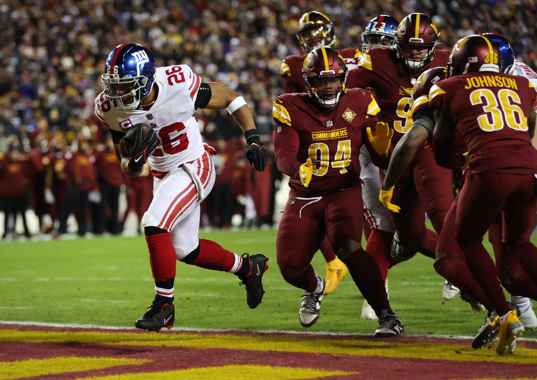New York Giants running back Saquon Barkley runs through the Washington Commanders defense for a touchdown. 