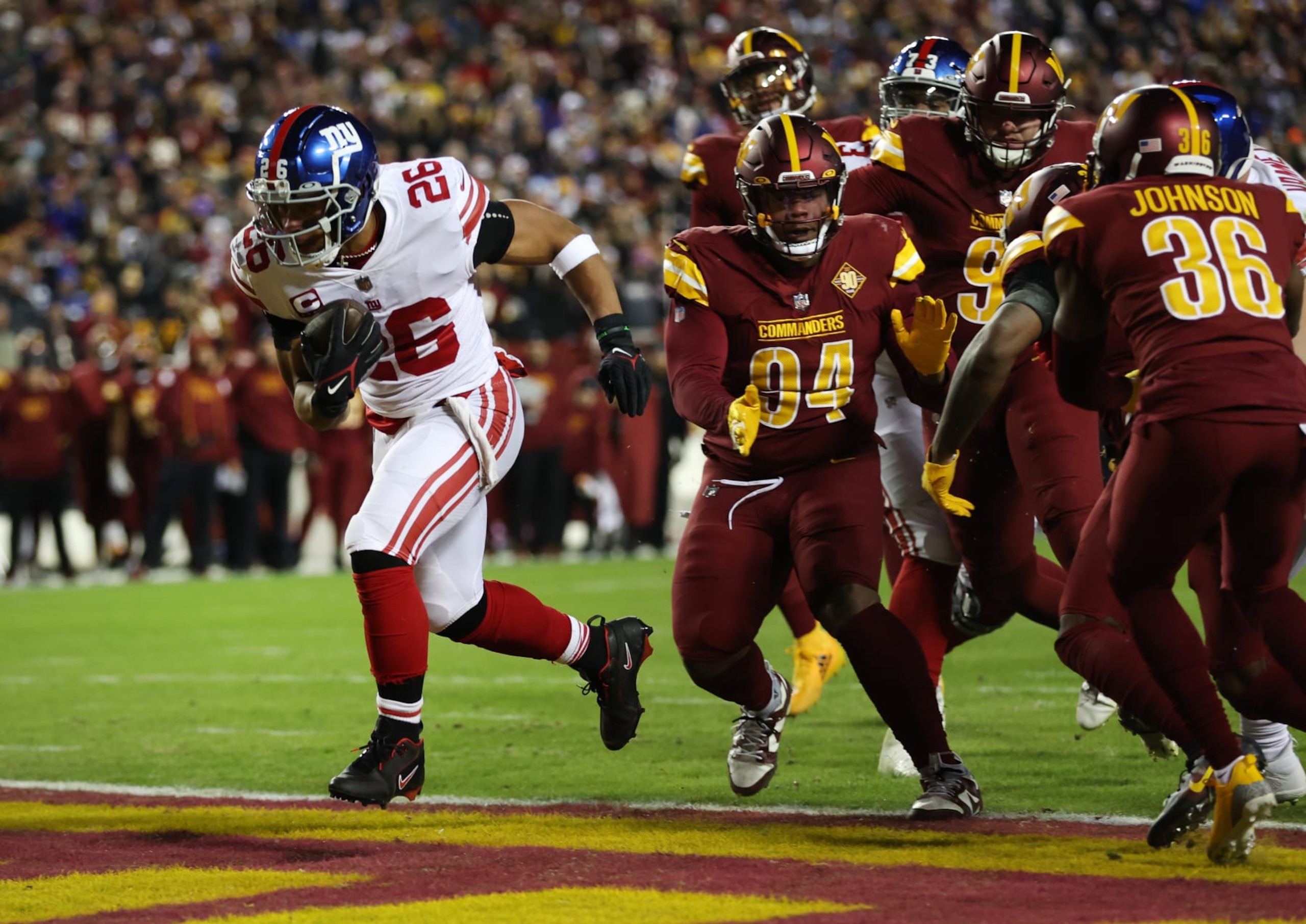 New York Giants running back Saquon Barkley runs through the Washington Commanders defense for a touchdown. 