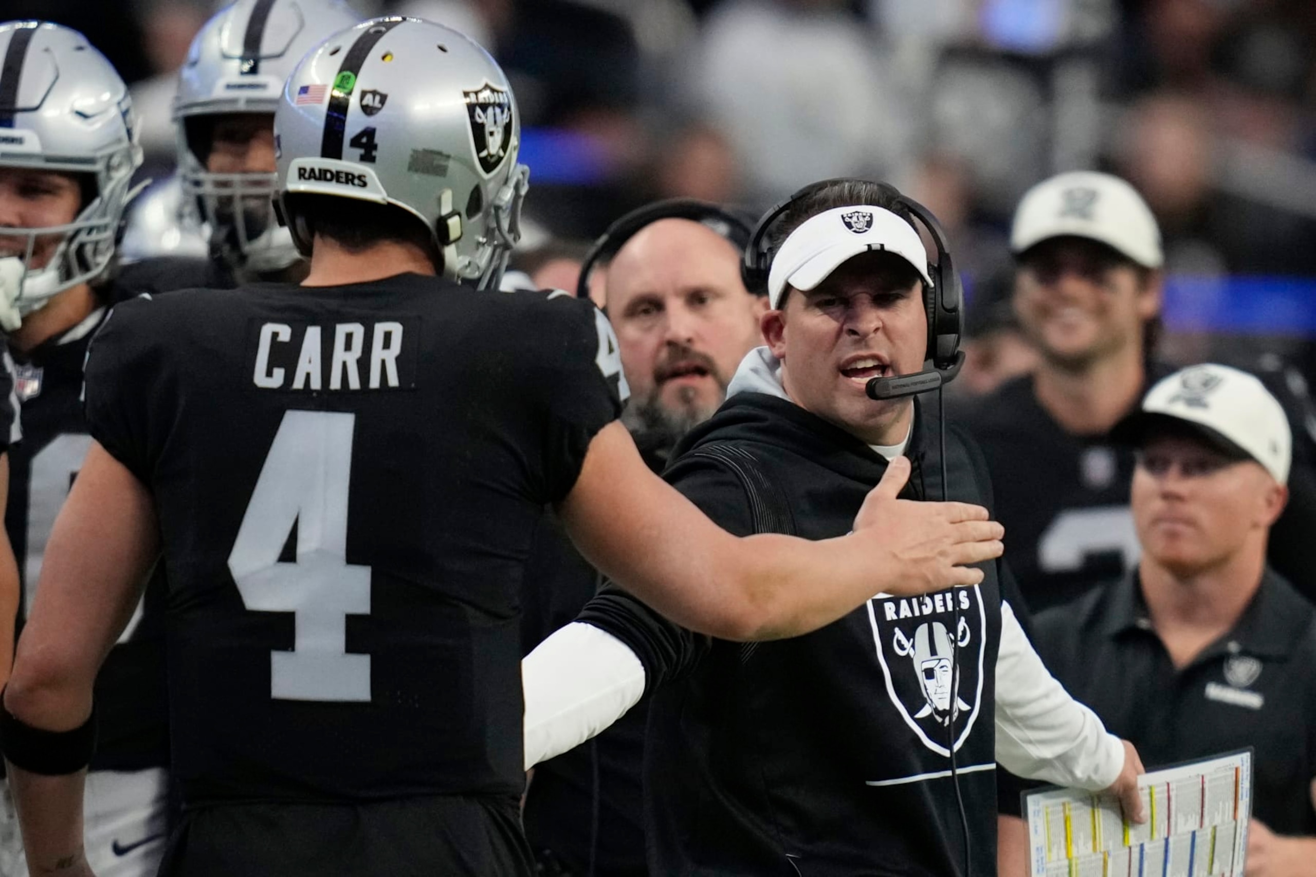 Las Vegas Raiders quarterback Derek Carr is congratulated Las Vegas Raiders head coach Josh McDaniels after a touchdown pass during the first half of an NFL football game between the New England Patriots and Las Vegas Raiders, Sunday, Dec. 18, 2022, in Las Vegas. (AP Photo/John Locher)