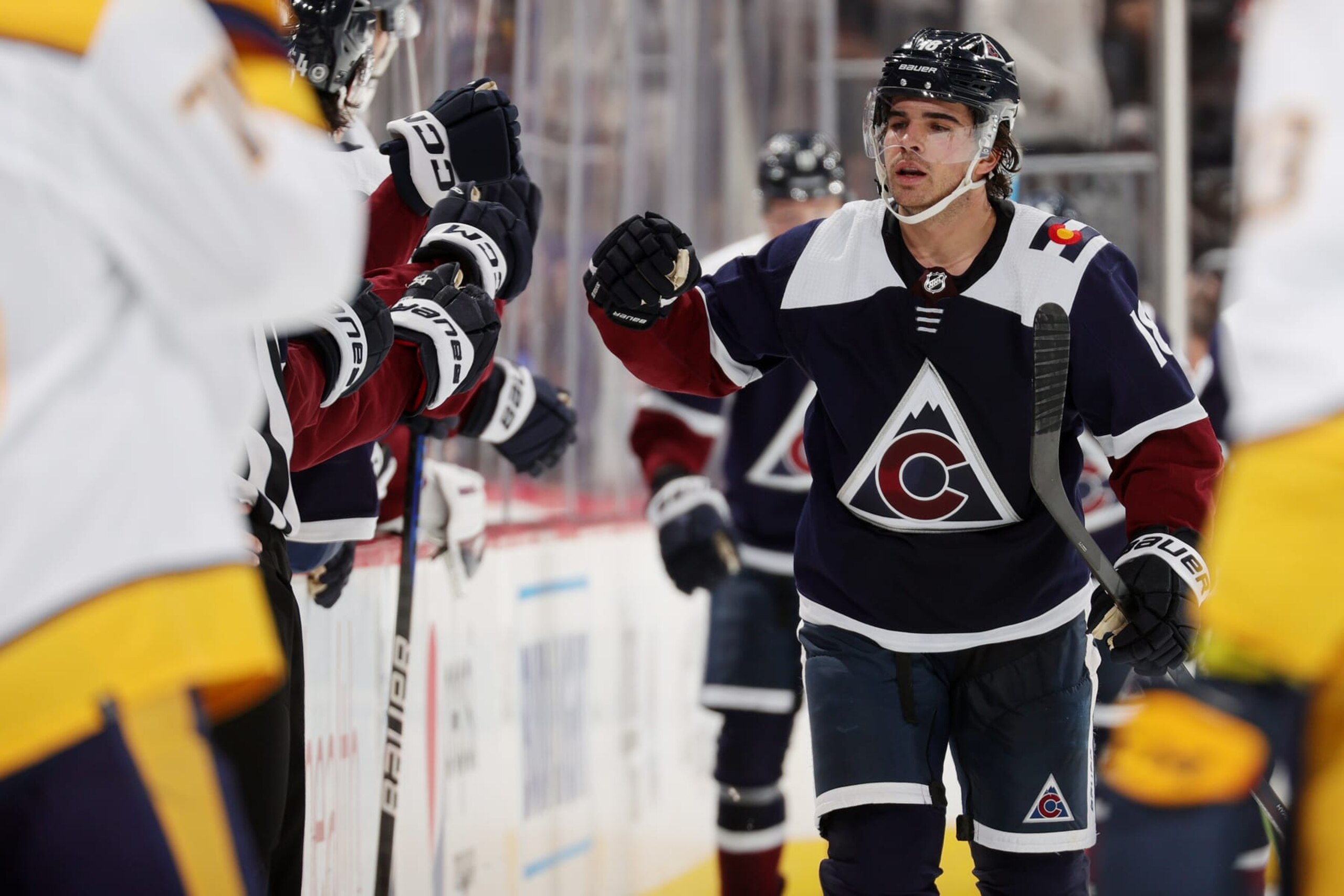DENVER, COLORADO - DECEMBER 17: Alex Newhook #18 of the Colorado Avalanche celebrates with his bench after scoring a goal against the Nashville Predators at Ball Arena on December 17, 2022 in Denver, Colorado. (Photo by Michael Martin/NHLI via Getty Images)