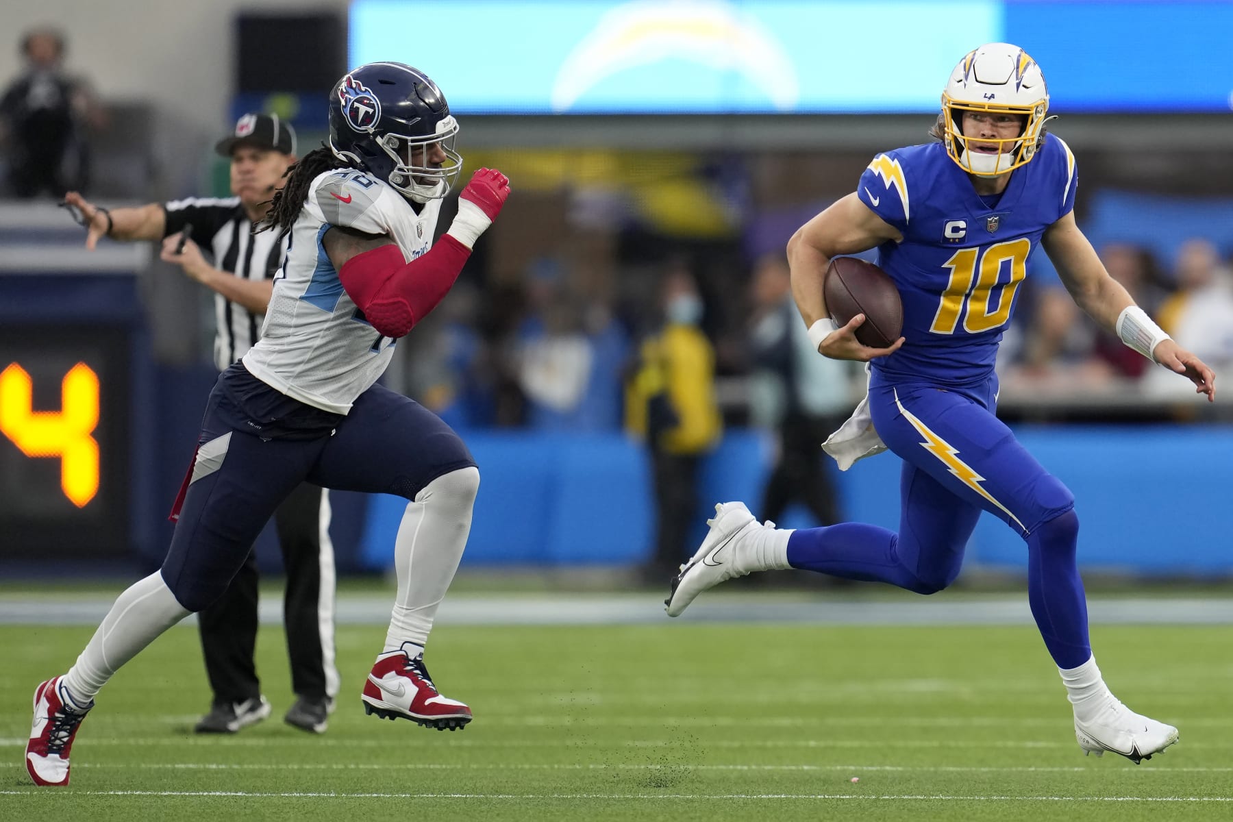 Los Angeles Chargers quarterback Justin Herbert (10) runs against Tennessee Titans linebacker Bud Dupree during the second half of an NFL football game in Inglewood, Calif., Sunday, Dec. 18, 2022. (AP Photo/Marcio Jose Sanchez)