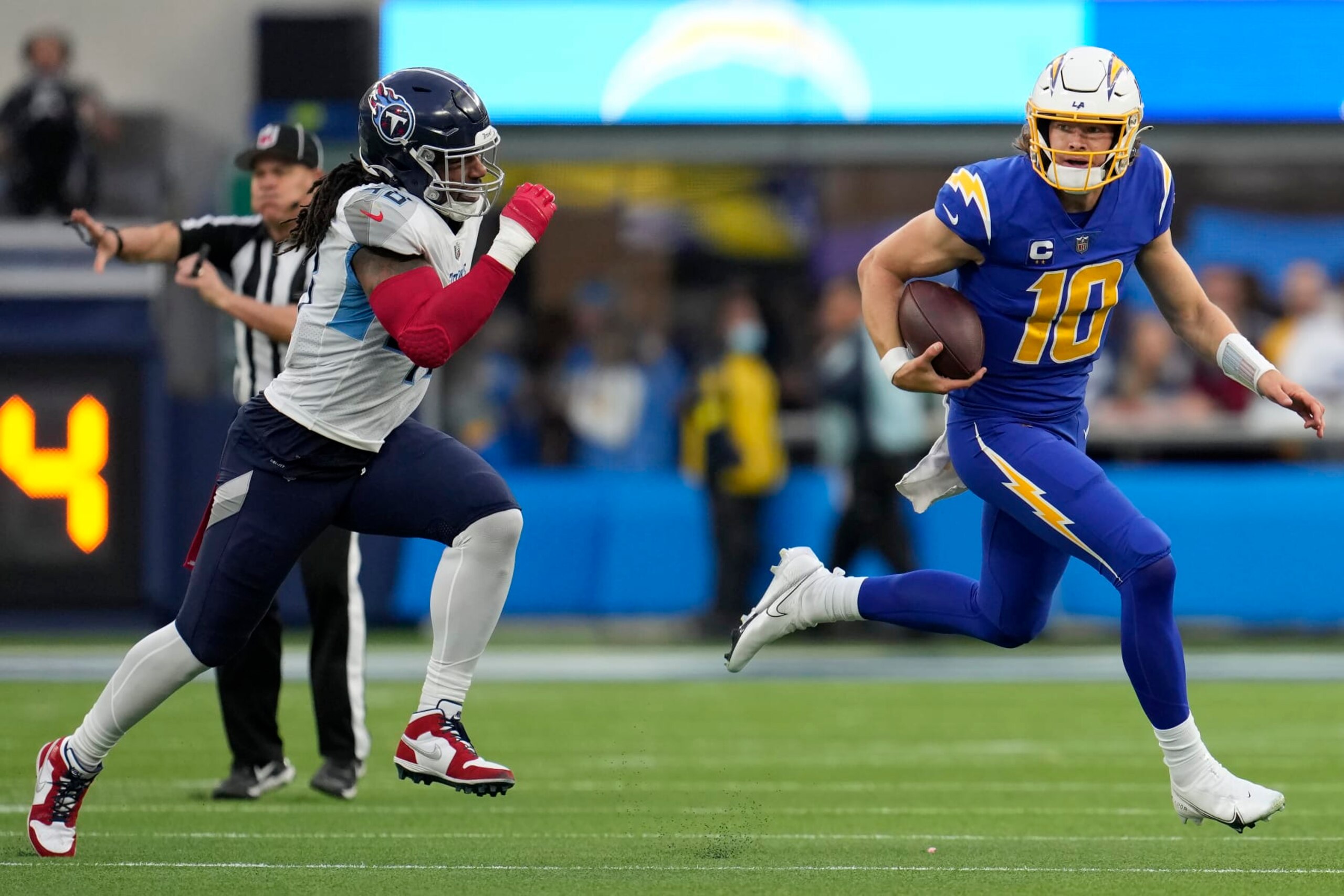 Los Angeles Chargers quarterback Justin Herbert (10) runs against Tennessee Titans linebacker Bud Dupree during the second half of an NFL football game in Inglewood, Calif., Sunday, Dec. 18, 2022. (AP Photo/Marcio Jose Sanchez)