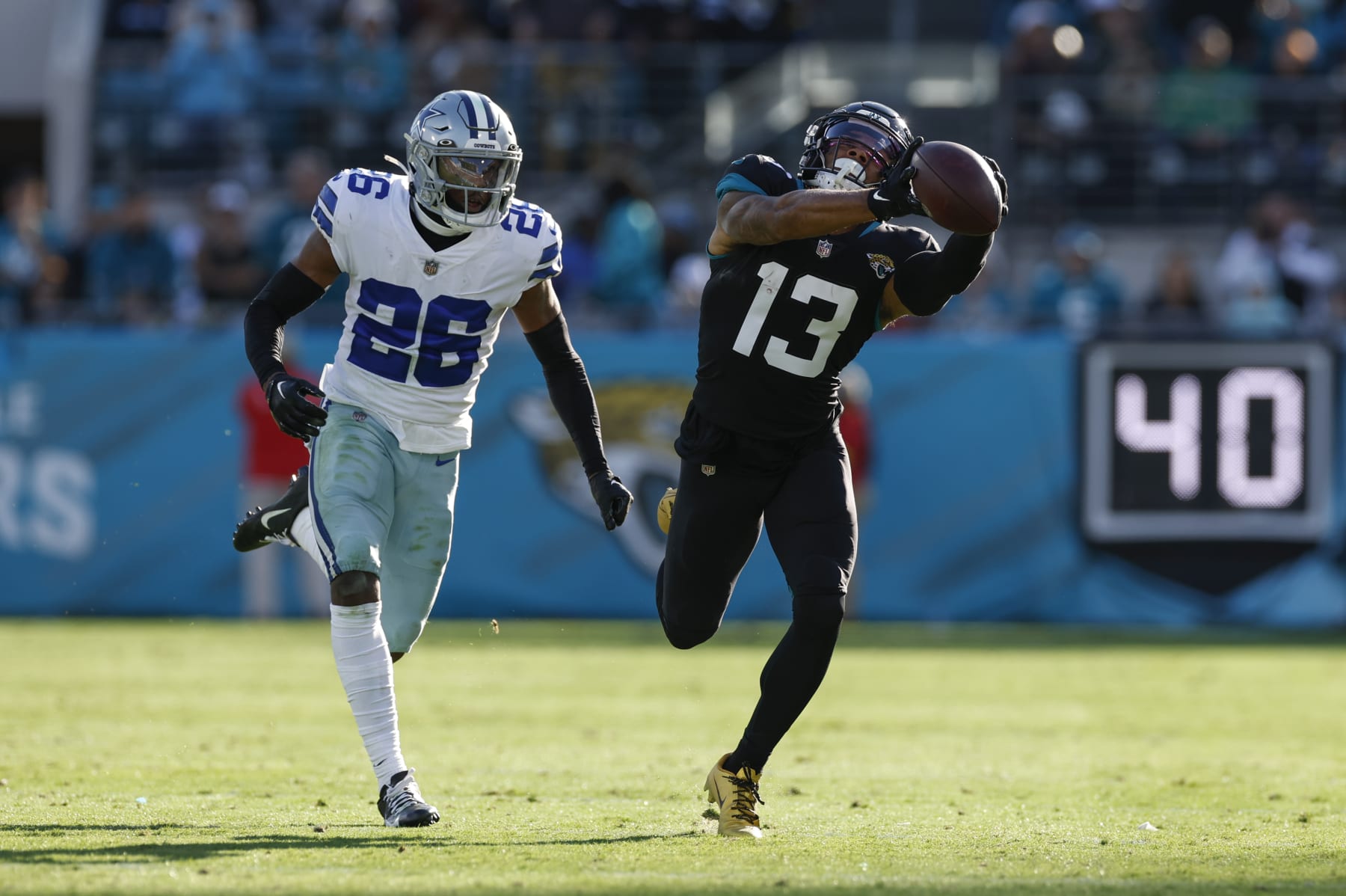 JACKSONVILLE, FL - DECEMBER 18: Jacksonville Jaguars wide receiver Christian Kirk (13) catches a pass while defended by Dallas Cowboys cornerback DaRon Bland (26) during the game between the Dallas Cowboys and the Jacksonville Jaguars on December 18, 2022 at tIAA Bank Field in Jacksonville, Fl. (Photo by David Rosenblum/Icon Sportswire via Getty Images)