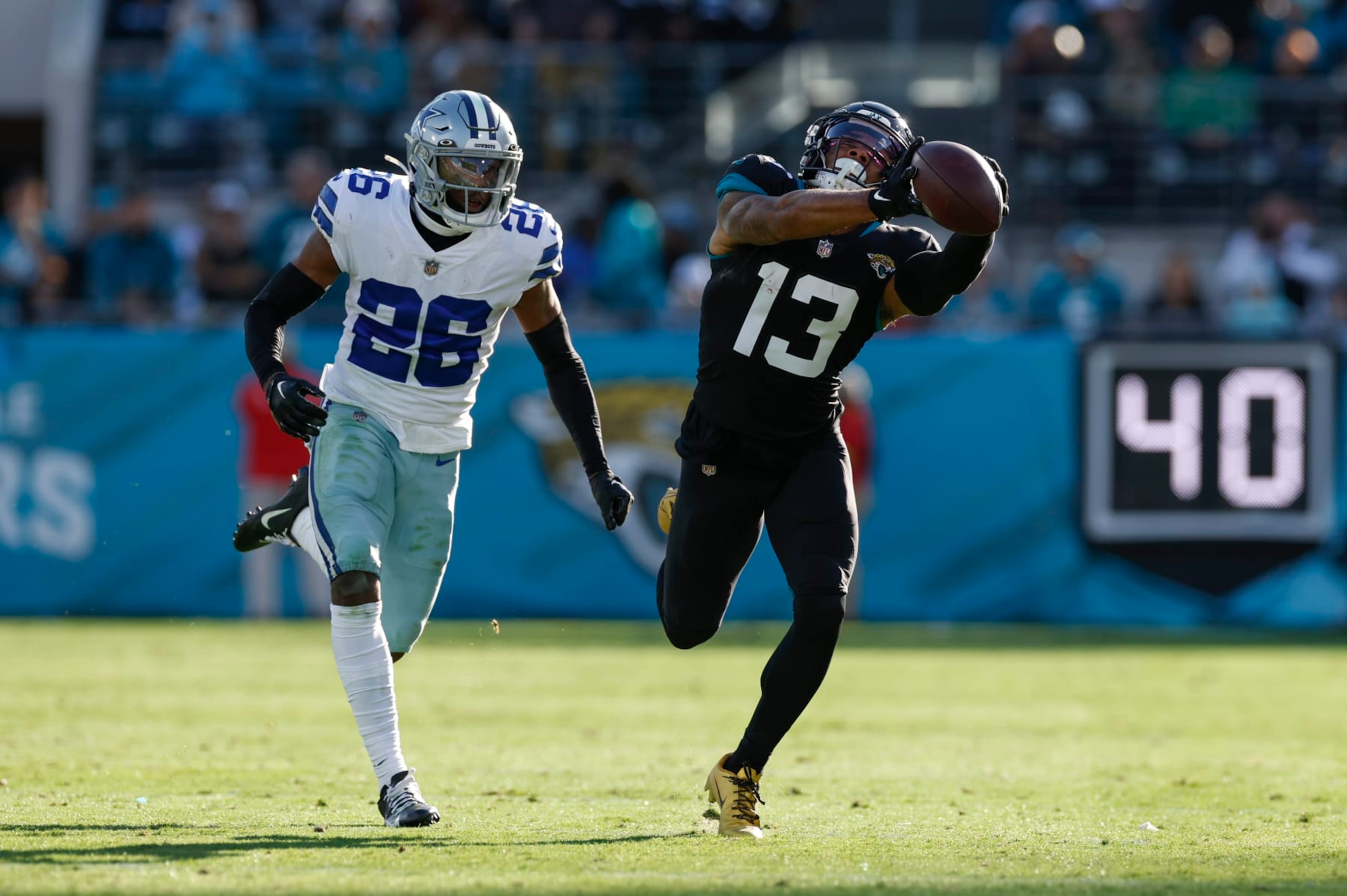 JACKSONVILLE, FL - DECEMBER 18: Jacksonville Jaguars wide receiver Christian Kirk (13) catches a pass while defended by Dallas Cowboys cornerback DaRon Bland (26) during the game between the Dallas Cowboys and the Jacksonville Jaguars on December 18, 2022 at tIAA Bank Field in Jacksonville, Fl. (Photo by David Rosenblum/Icon Sportswire via Getty Images)