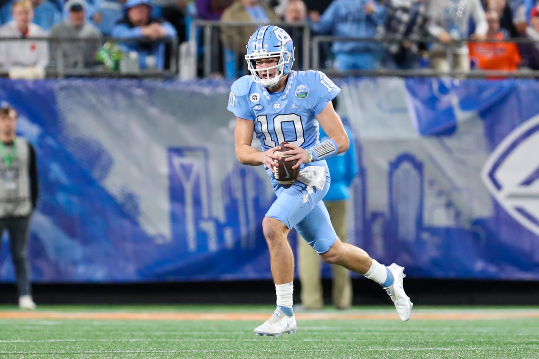 CHARLOTTE, NC - DECEMBER 03: Drake Maye (10) of the North Carolina Tar Heels scrambles with the ball during the ACC Championship football game between the North Carolina Tar Heels and the Clemson Tigers on December 3, 2022 at Bank of America Stadium in Charlotte, NC. (Photo by David Jensen/Icon Sportswire via Getty Images)