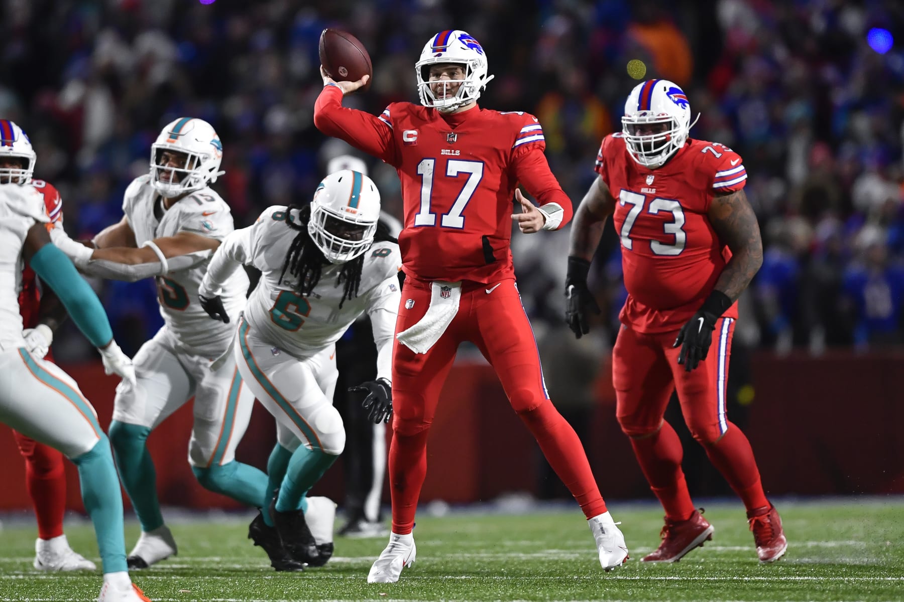 Buffalo Bills quarterback Josh Allen (17) throws a pass while pressured by Miami Dolphins linebacker Melvin Ingram (6) during the second half of an NFL football game in Orchard Park, N.Y., Saturday, Dec. 17, 2022. (AP Photo/Adrian Kraus)