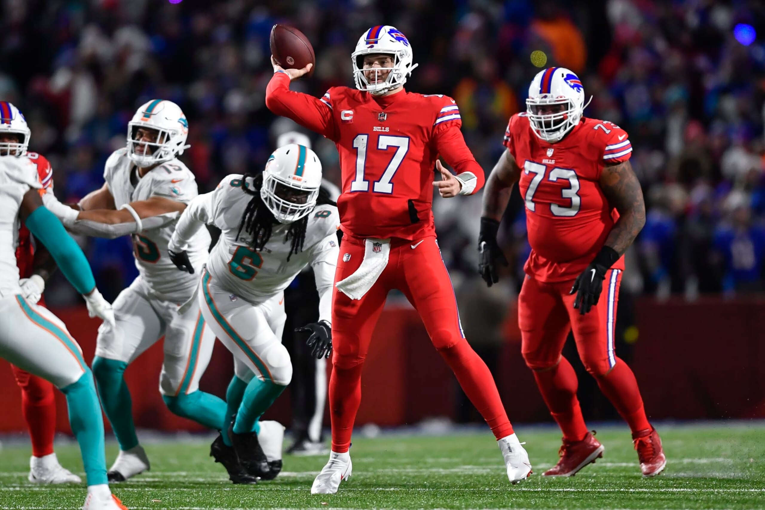 Buffalo Bills quarterback Josh Allen (17) throws a pass while pressured by Miami Dolphins linebacker Melvin Ingram (6) during the second half of an NFL football game in Orchard Park, N.Y., Saturday, Dec. 17, 2022. (AP Photo/Adrian Kraus)