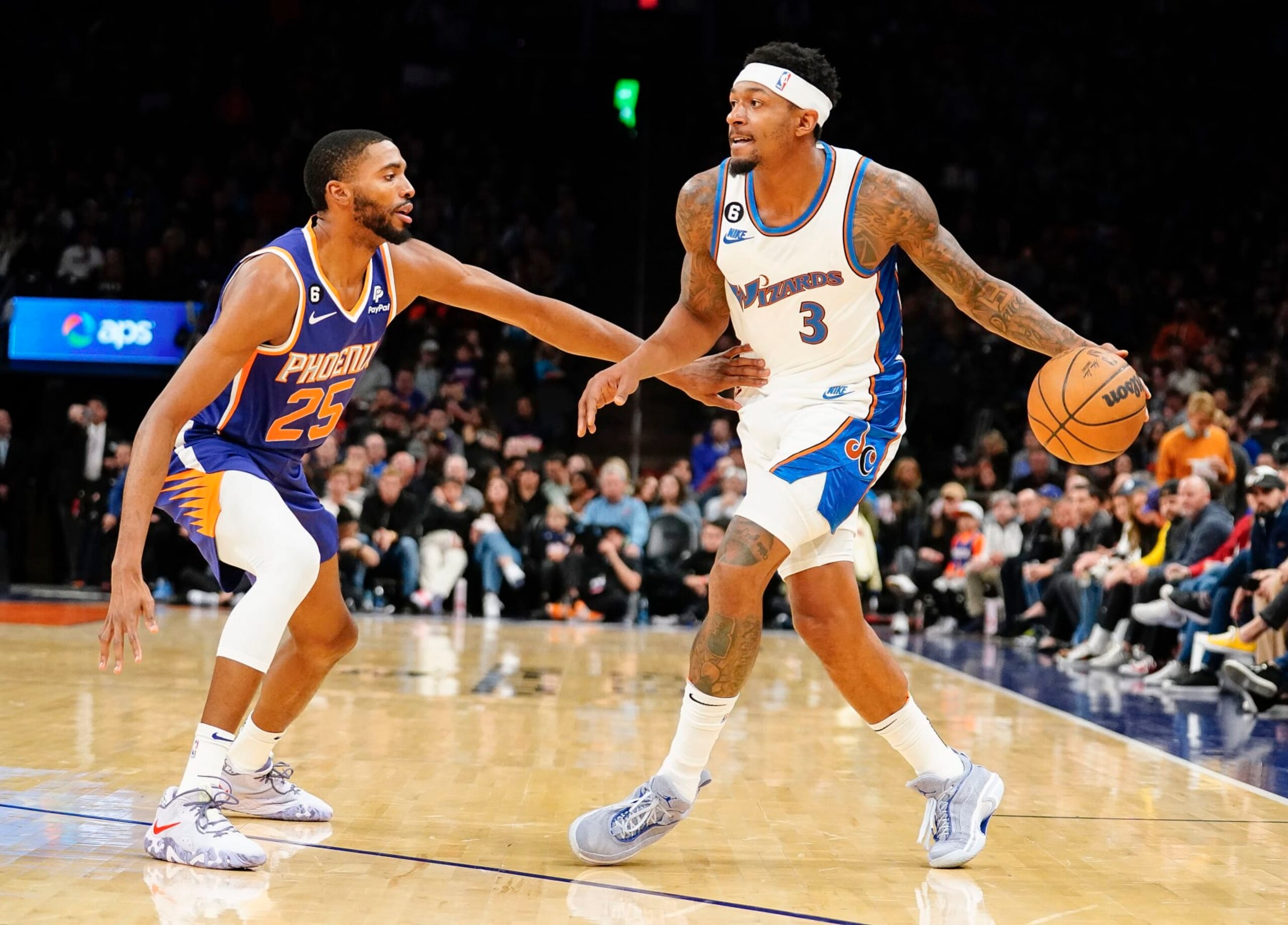 Phoenix Suns' Mikal Bridges (25) guards Washington Wizards' Bradley Beal (3) during the first half of an NBA basketball game in Phoenix, Tuesday, Dec. 20, 2022. (AP Photo/Darryl Webb)