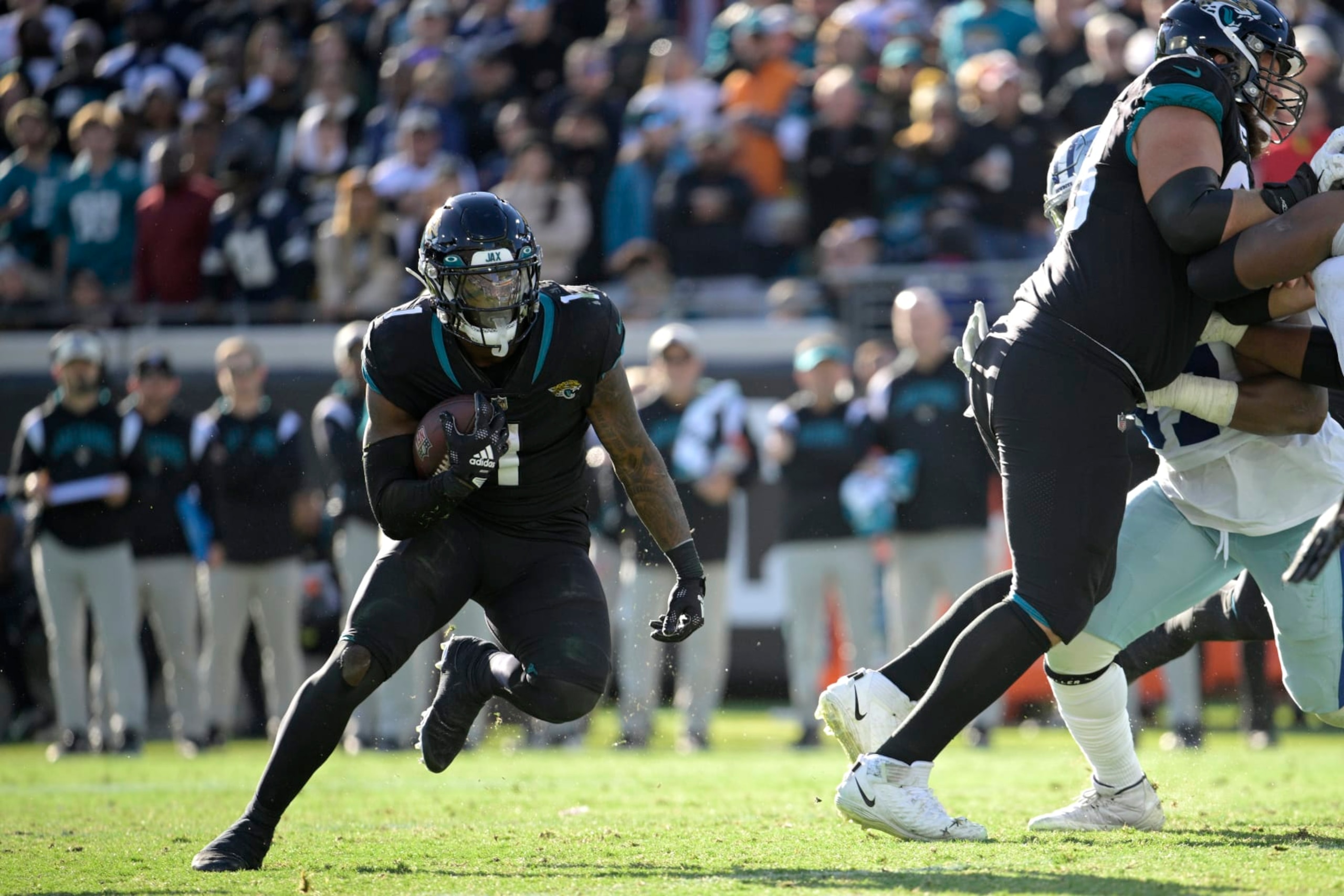 Jacksonville Jaguars running back Travis Etienne Jr. (1) rushes for yardage during the second half of an NFL football game against the Dallas Cowboys, Sunday, Dec. 18, 2022, in Jacksonville, Fla. (AP Photo/Phelan M. Ebenhack)