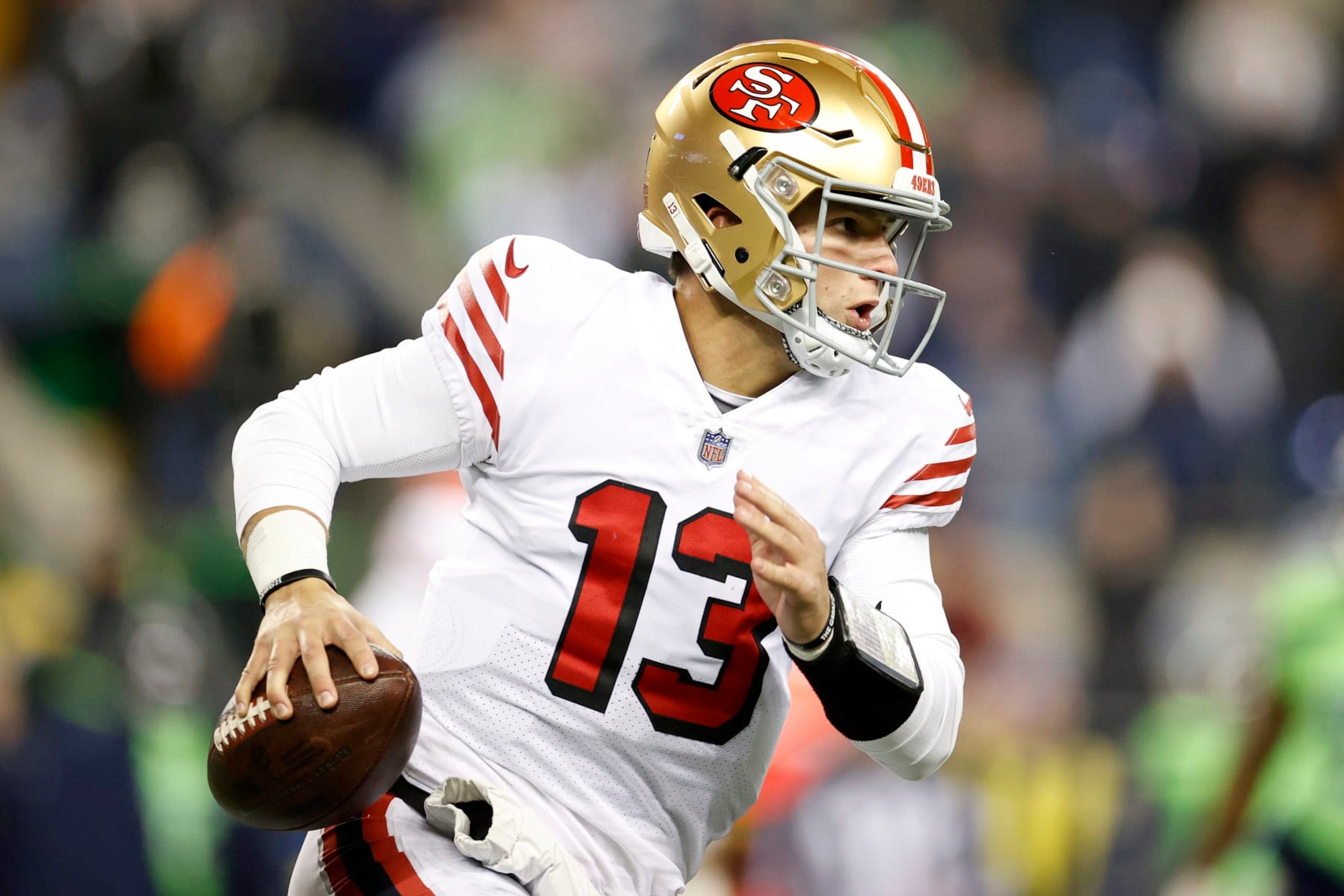 SEATTLE, WASHINGTON - DECEMBER 15: Brock Purdy #13 of the San Francisco 49ers carries the ball against the Seattle Seahawks at Lumen Field on December 15, 2022 in Seattle, Washington. (Photo by Steph Chambers/Getty Images)