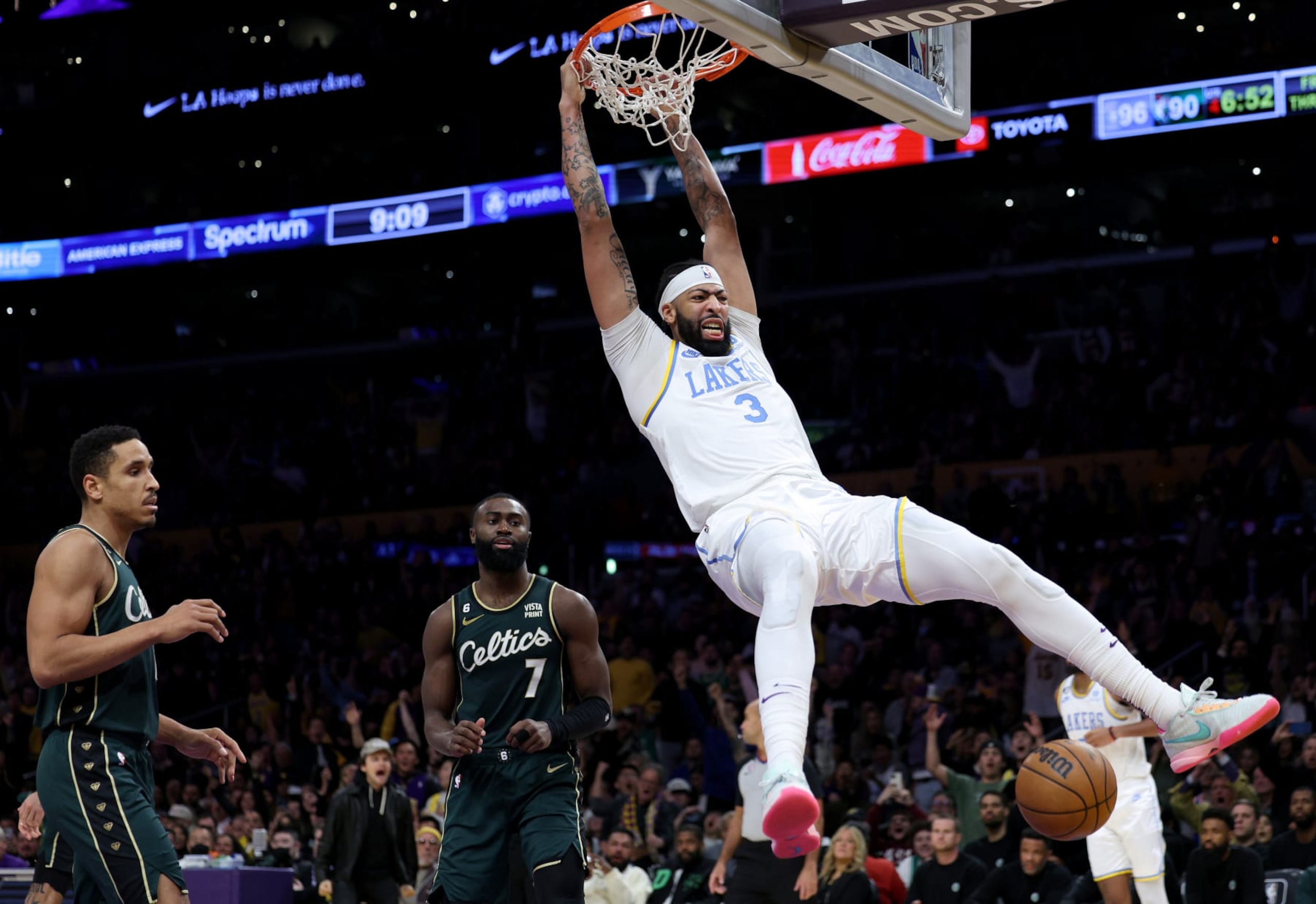 Anthony Davis #3 of the Los Angeles Lakers reacts to his dunk in front of Malcolm Brogdon #13 and Jaylen Brown #7 of the Boston Celtics during a 122-118 loss to the Celtics at Crypto.com Arena on December 13, 2022 in Los Angeles, California. NOTE TO USER: User expressly acknowledges and agrees that, by downloading and/or using this photograph, User is consenting to the terms and conditions of the Getty Images License Agreement. Mandatory Copyright Notice: Copyright 2022 NBAE. (Photo by Harry How/Getty Images)