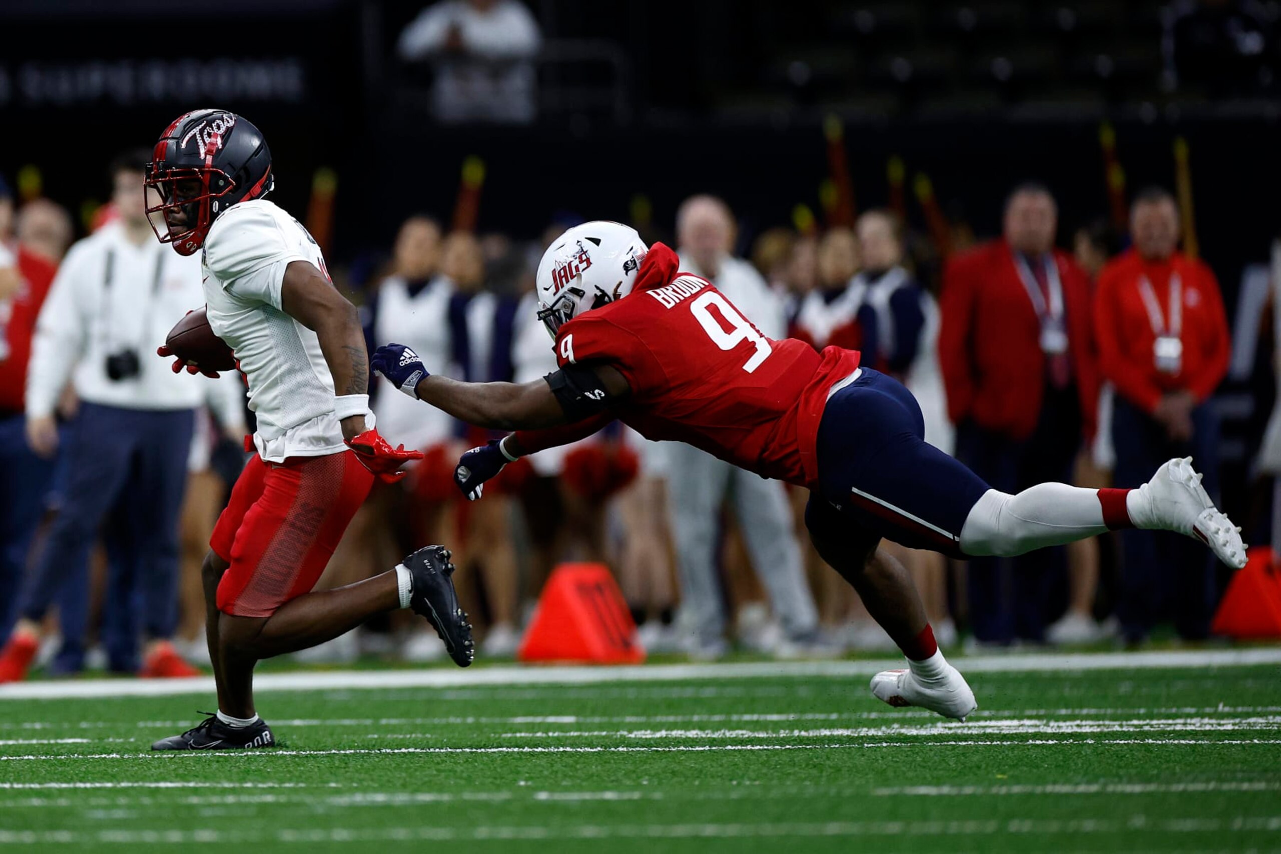 Malachi Corley runs from Ke'Shun Brown