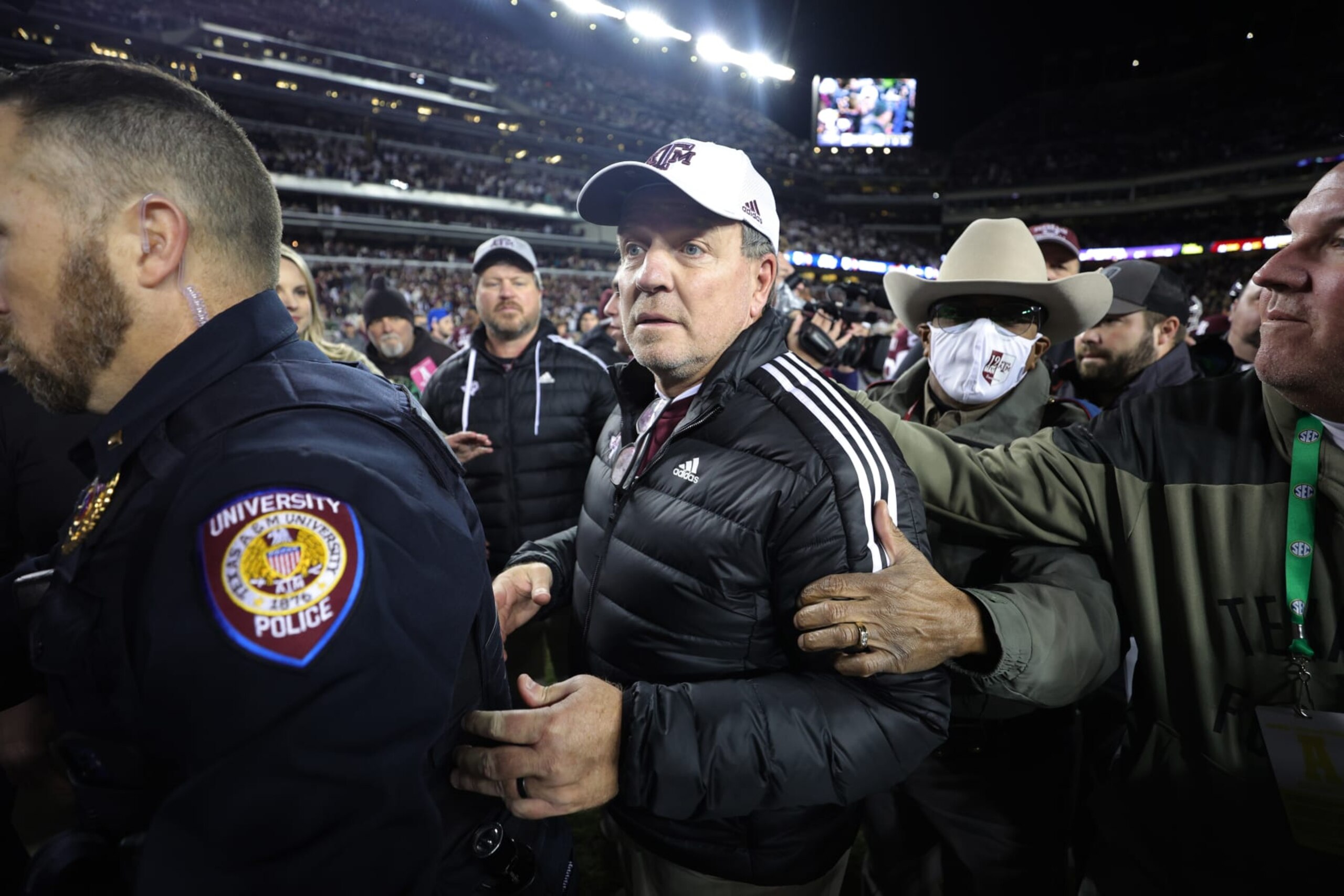 COLLEGE STATION, TEXAS - NOVEMBER 26: Head coach Jimbo Fisher of the Texas A&M Aggies  is escorted off the field following a win over the LSU Tigers at Kyle Field on November 26, 2022 in College Station, Texas. (Photo by Carmen Mandato/Getty Images)