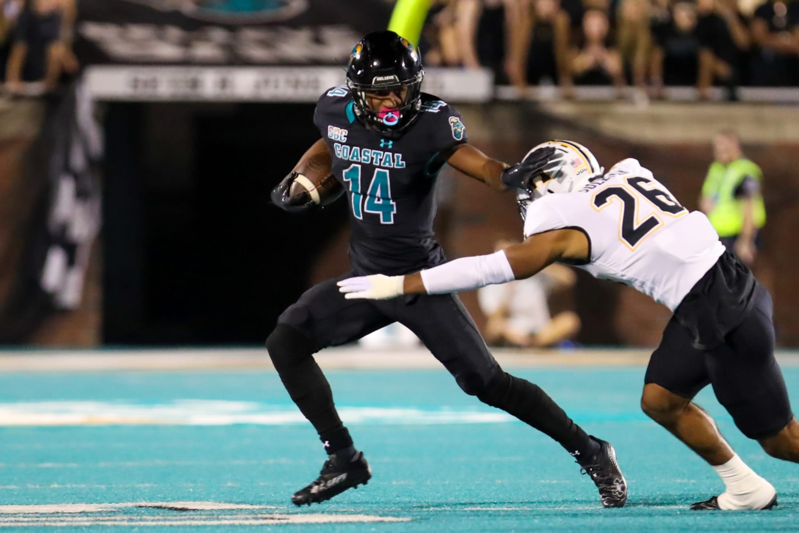 CONWAY, SC - NOVEMBER 03: Jared Brown (14) of the Coastal Carolina Chanticleers runs the ball and attempts to avoid a tackle by Caden Sullivan (26) of the Appalachian State Mountaineers during a football game between the Coastal Carolina Chanticleers and the Appalachian State Mountaineers on November 3, 2022, at Brooks Stadium in Conway, SC. (Photo by David Jensen/Icon Sportswire via Getty Images)