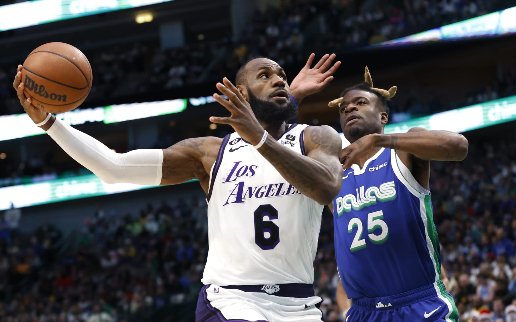 DALLAS, TX - DECEMBER 25: LeBron James #6 of the Los Angeles Lakers goes to the basket as Reggie Bullock #25 of the Dallas Mavericks defends in the first half at American Airlines Center on December 25, 2022 in Dallas, Texas. NOTE TO USER: User expressly acknowledges and agrees that, by downloading and or using this photograph, User is consenting to the terms and conditions of the Getty Images License Agreement. (Photo by Ron Jenkins/Getty Images)