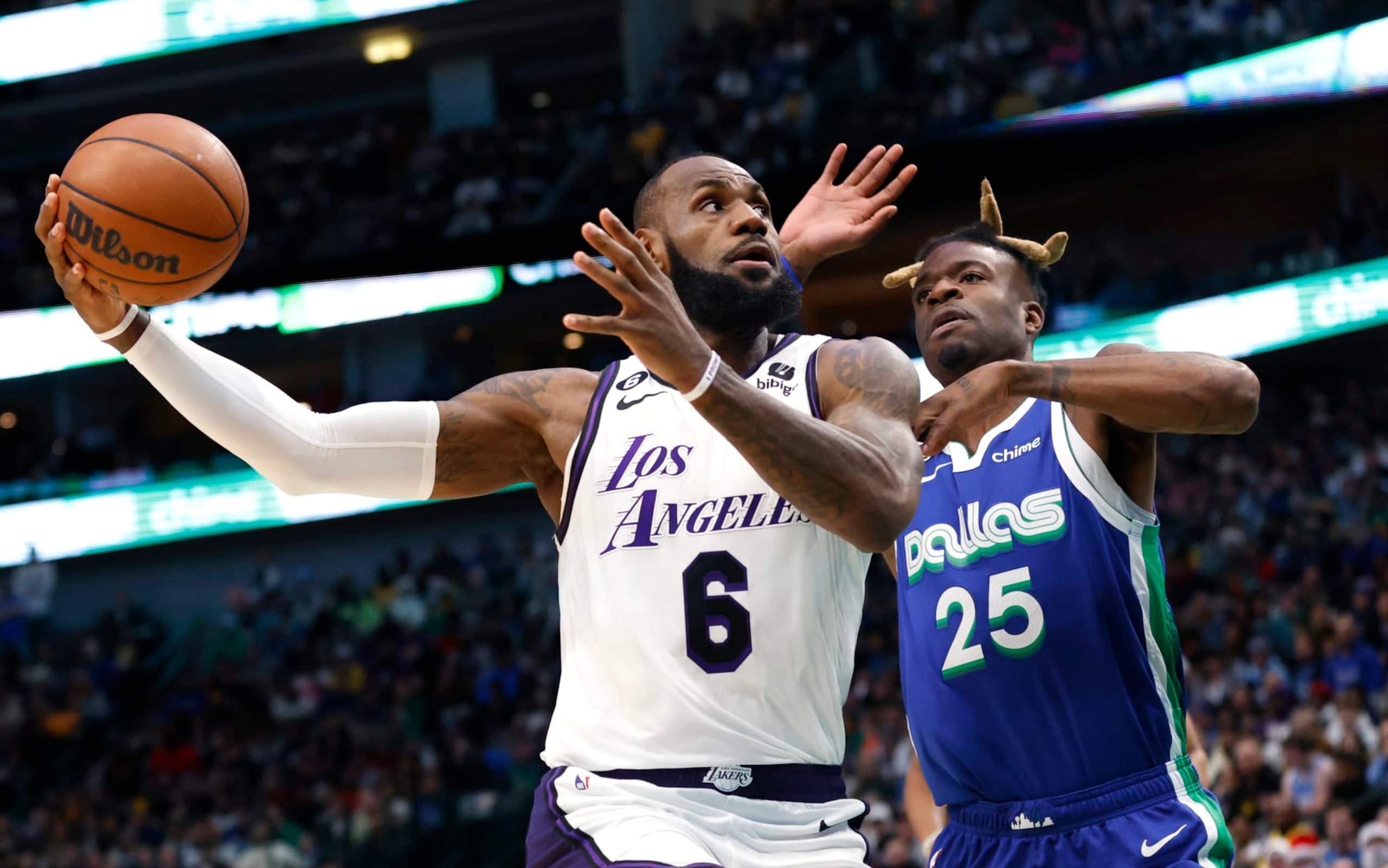 DALLAS, TX - DECEMBER 25: LeBron James #6 of the Los Angeles Lakers goes to the basket as Reggie Bullock #25 of the Dallas Mavericks defends in the first half at American Airlines Center on December 25, 2022 in Dallas, Texas. NOTE TO USER: User expressly acknowledges and agrees that, by downloading and or using this photograph, User is consenting to the terms and conditions of the Getty Images License Agreement. (Photo by Ron Jenkins/Getty Images)