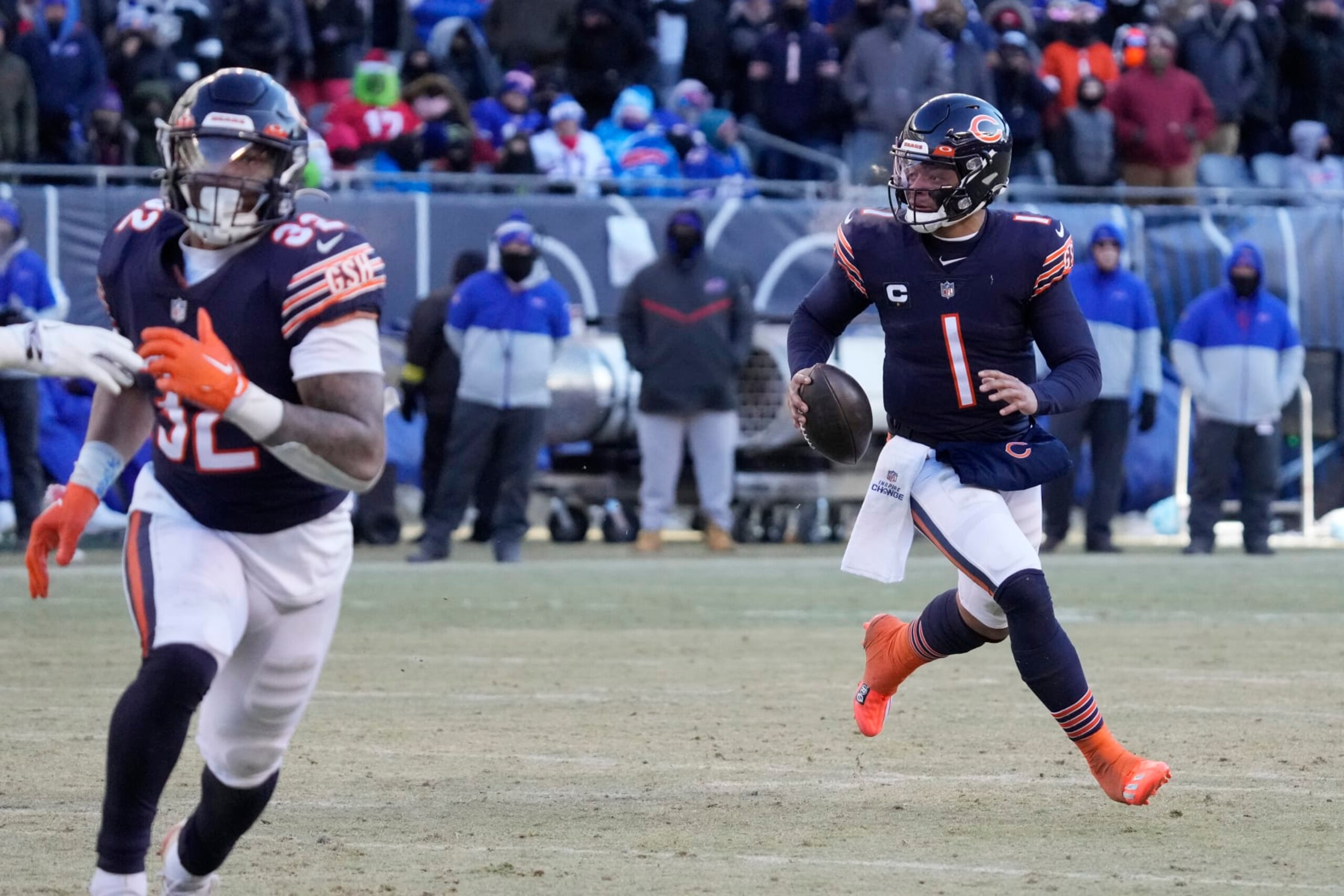 Chicago Bears quarterback Justin Fields, right, runs as he looks to pass against the Buffalo Bills during the second half of an NFL football game, Saturday, Dec. 24, 2022, in Chicago. The Bills won 35-13. (AP Photo/Nam Y. Huh)