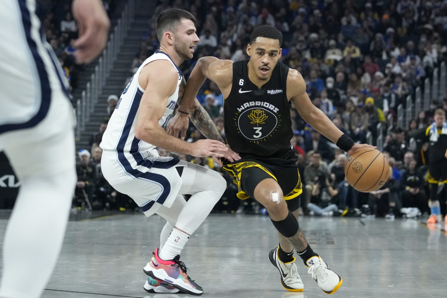 Golden State Warriors guard Jordan Poole, right, drives to the basket against Memphis Grizzlies guard John Konchar during the first half of an NBA basketball game in San Francisco, Sunday, Dec. 25, 2022. (AP Photo/Godofredo A. Vásquez)