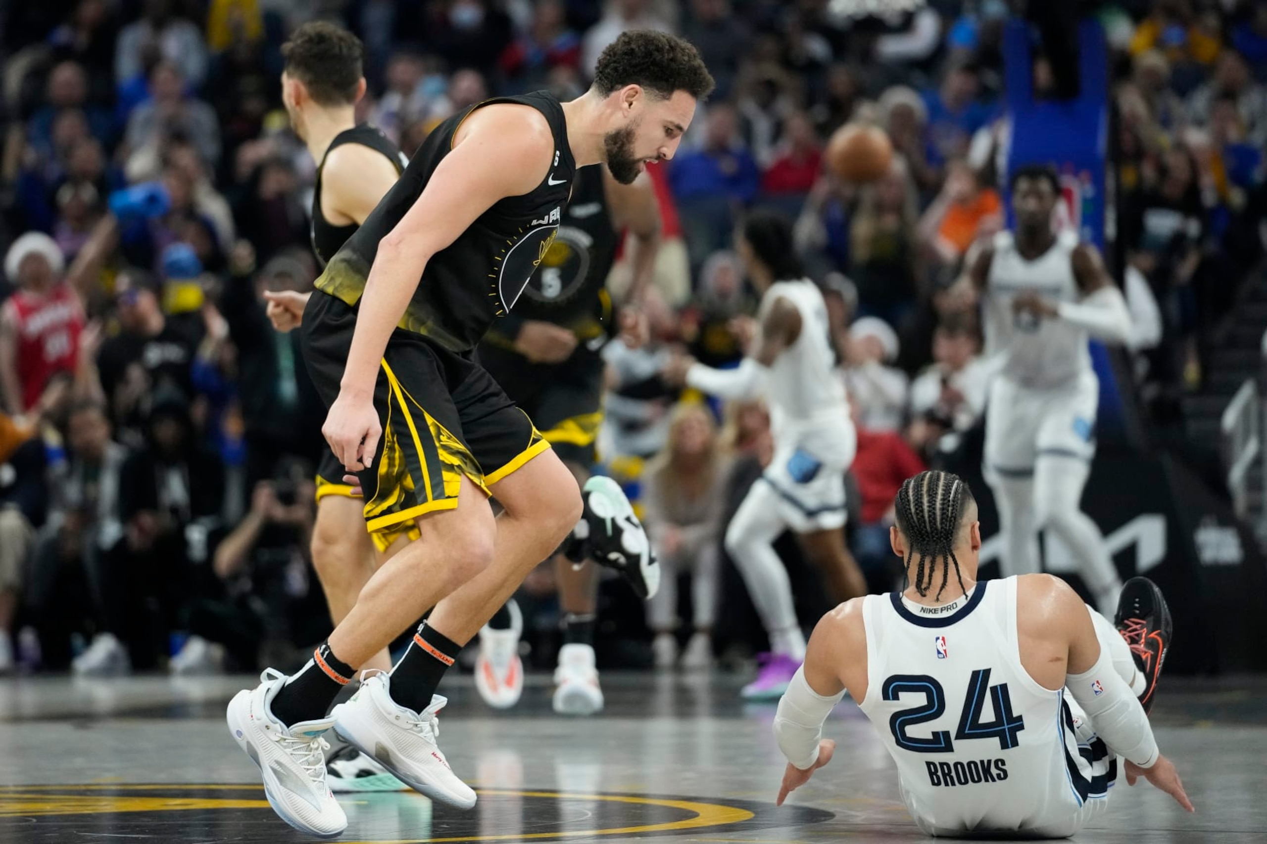 Golden State Warriors guard Klay Thompson, left, reacts next to Memphis Grizzlies forward Dillon Brooks after scoring during the second half of an NBA basketball game in San Francisco, Sunday, Dec. 25, 2022. (AP Photo/Godofredo A. Vásquez)